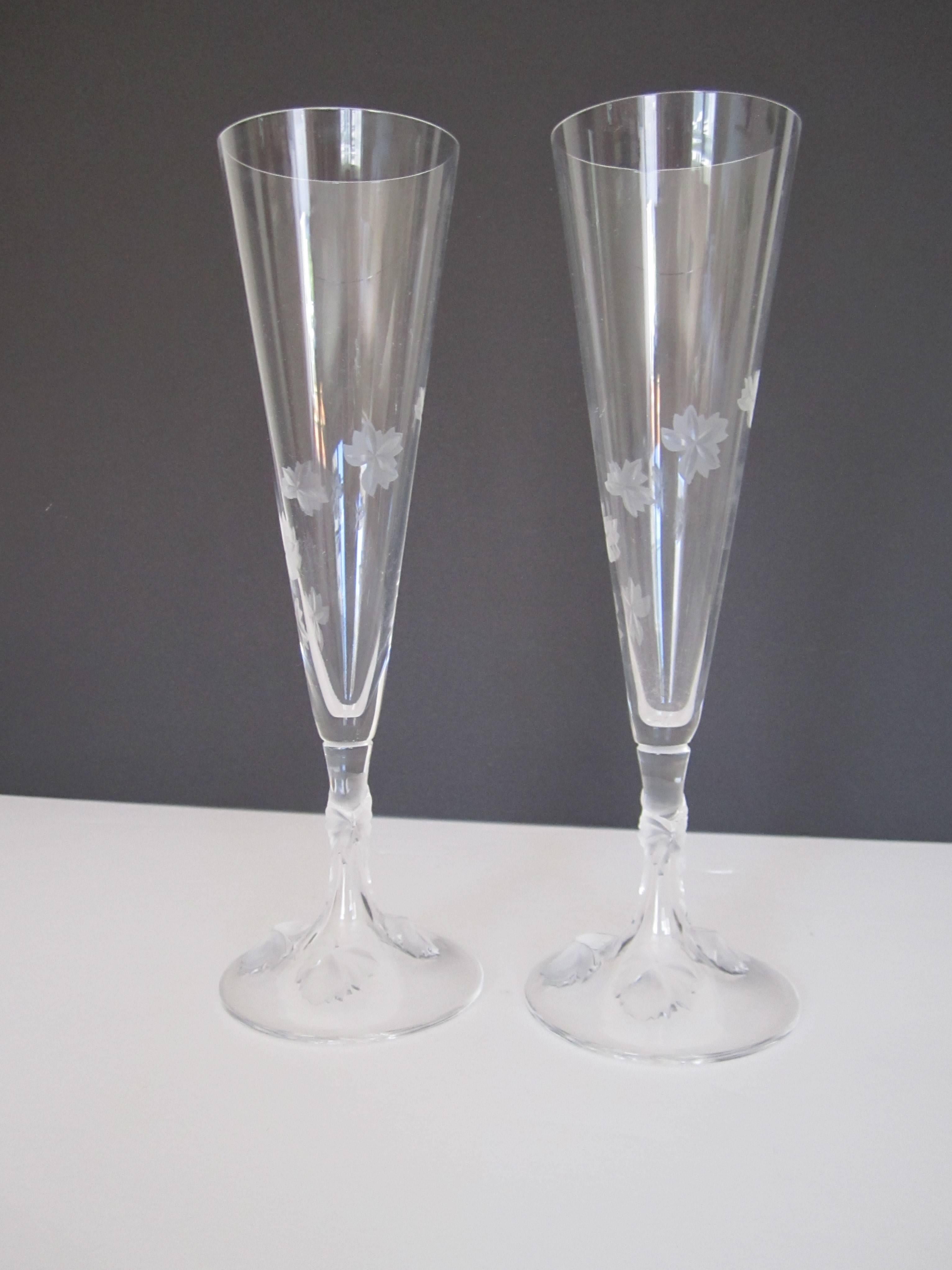 Pair/set available here for $500
A beautiful vintage pair of signed Lalique champagne flute glasses with raised decorative relief twisting up from base to stem to flute. Signed underneath on base as shown in image. Made in France. 

10 in. H

Pair