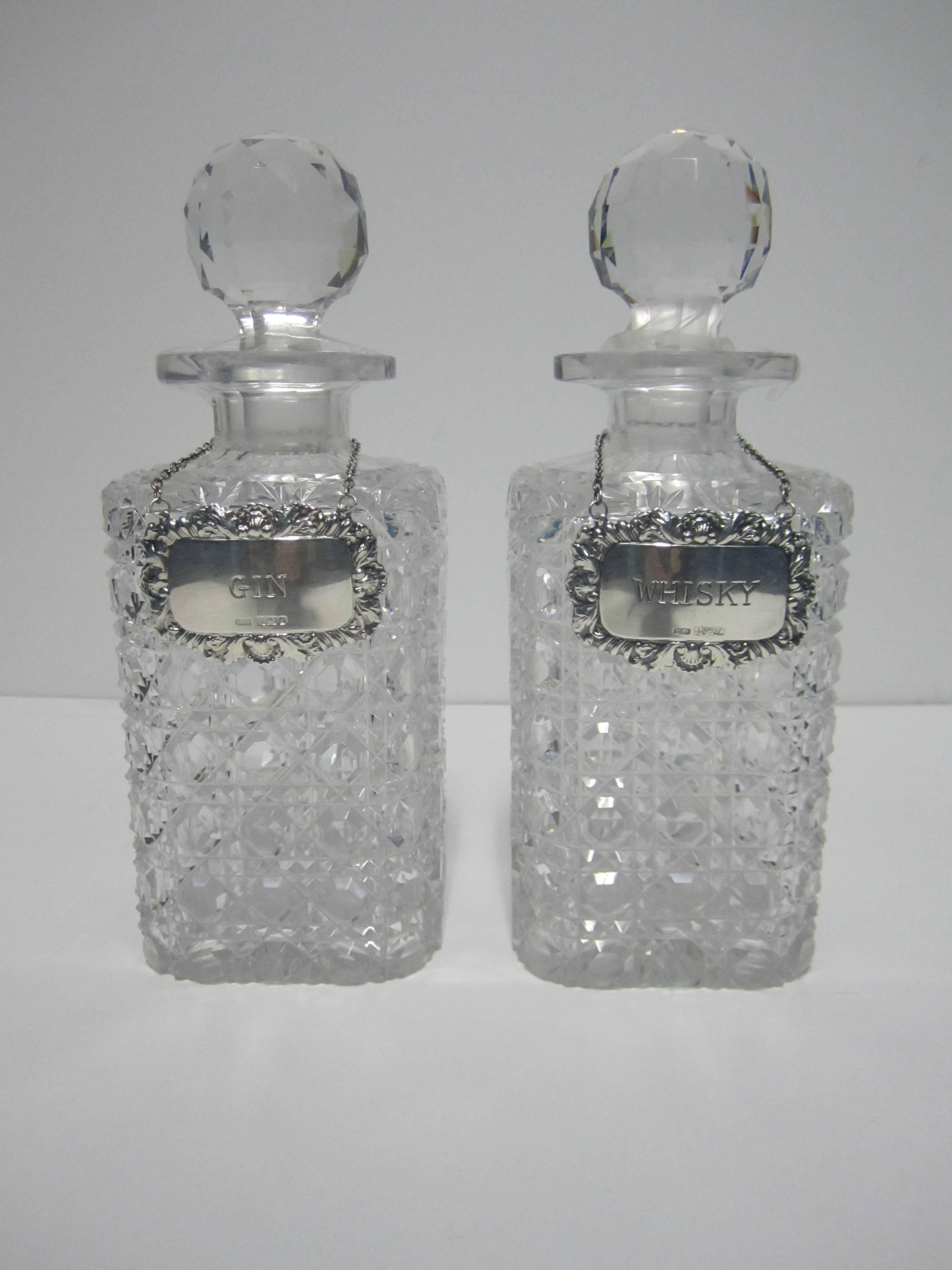 An antique pair of 'brilliant cut' crystal decanters, circa 20th Century, with English sterling silver 'GIN' and 'WHISKEY' bottle 'labels' or decanter 'tickets'. Sterling silver 'labels' are marked. Pair available here online. By request, pair can