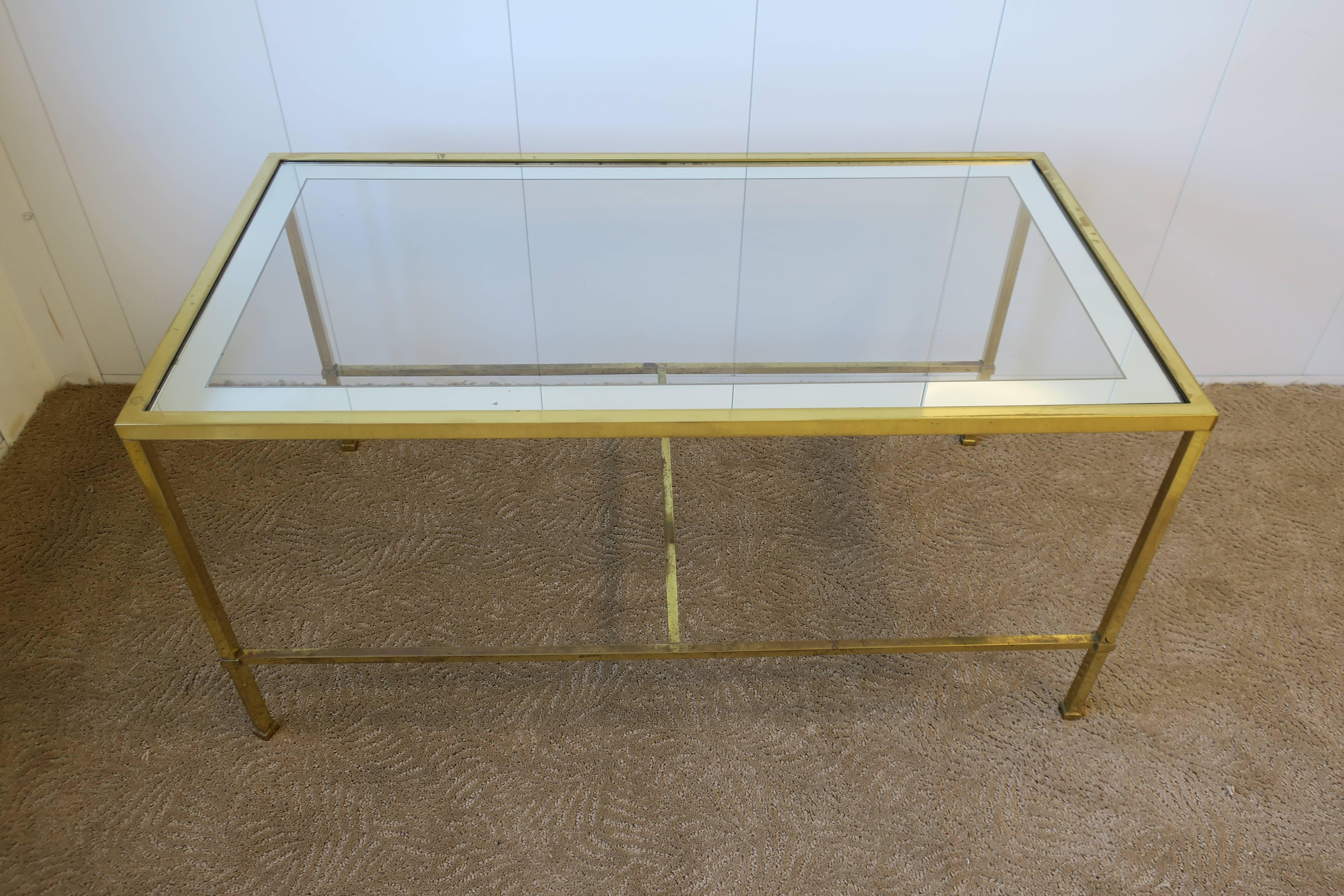 Elegant vintage Modern or Minimalist style rectangular brass and glass cocktail/coffee table in the style of Harvey Probber or Paul McCobb. This rectangular cocktail or coffee table has an inset glass top, 2 inch mirrored detail around edge, and