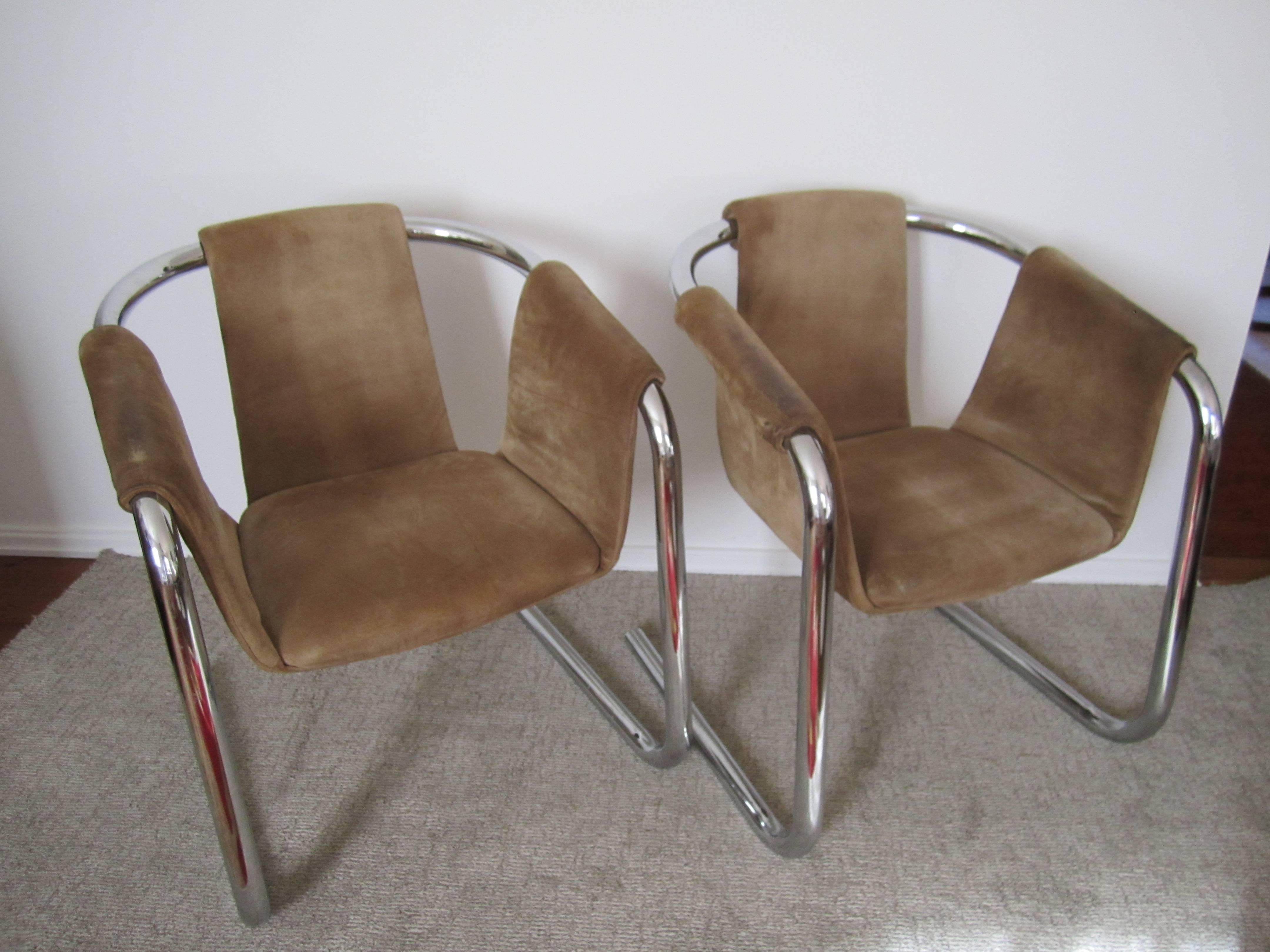 A pair of Post-Modern [Postmodern] or Modern style tubular chrome and tan suede sling arm cantilever lounge chairs, circa late-20th century, late-1970s to early '80s. Chairs are attributed to Zermatt by Vecta Group. 

