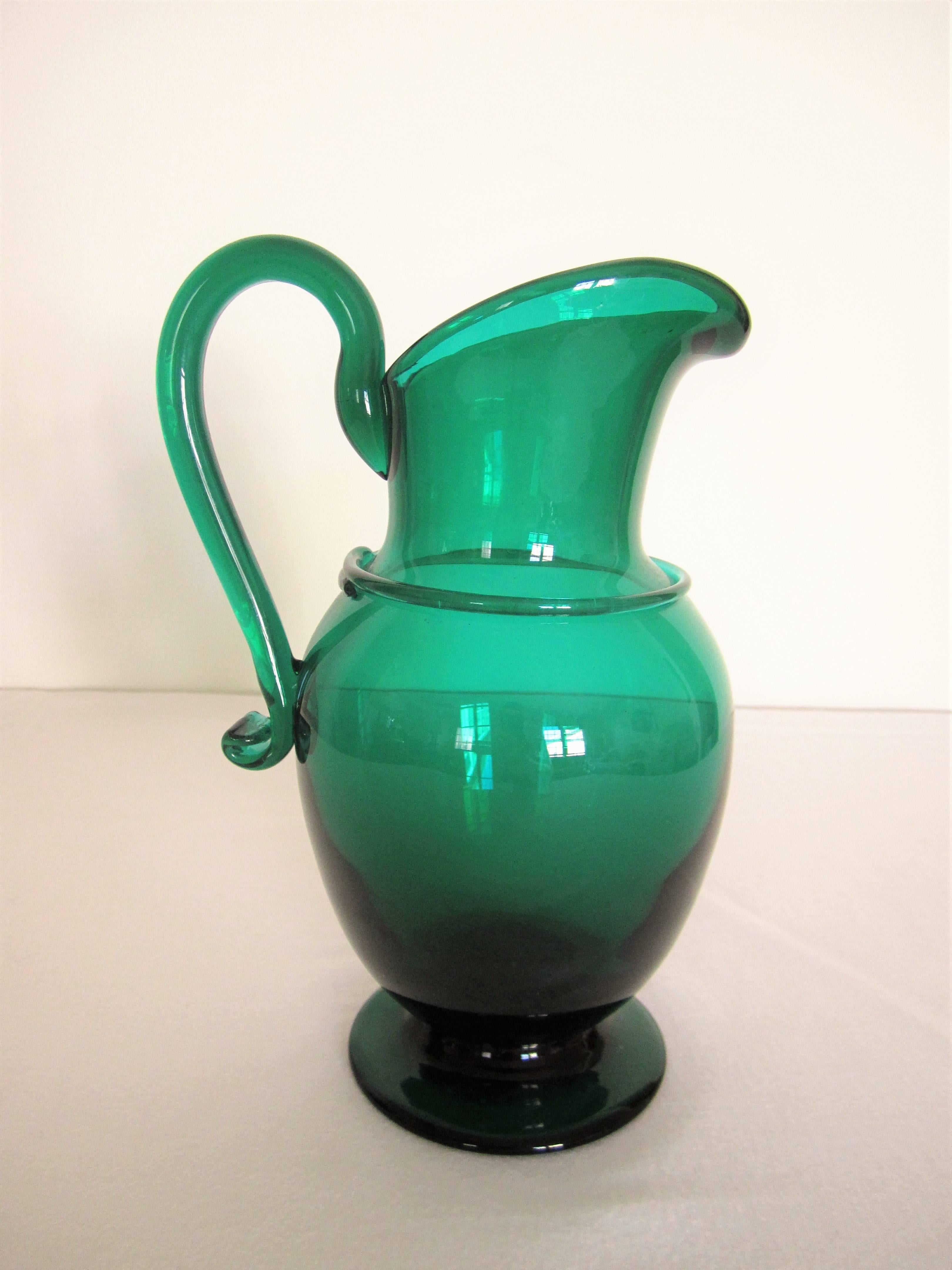 An emerald green handblown art glass pitcher or vase. Beautiful as a standalone piece or with flowers. 

Measures 9.75