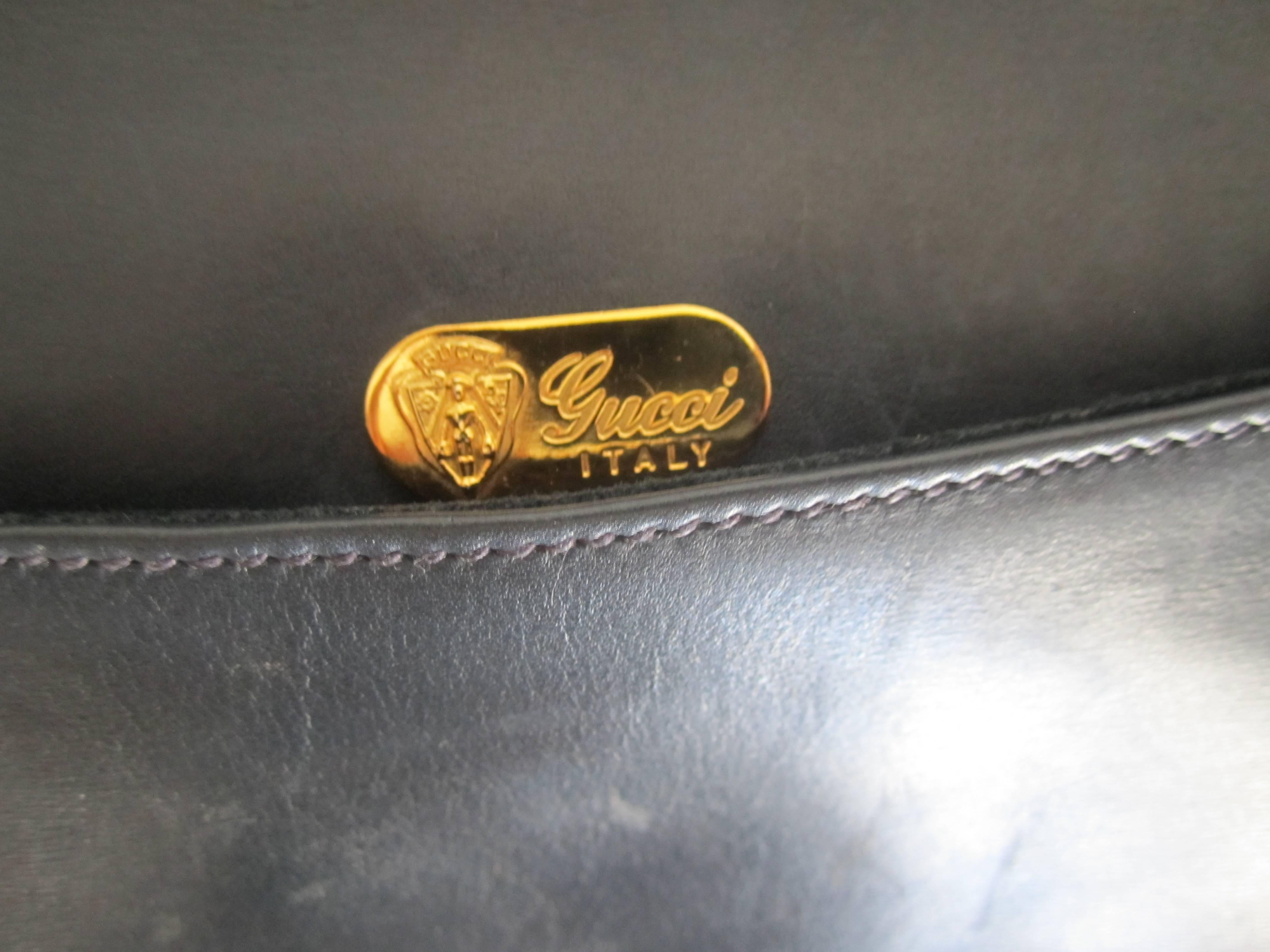 A chic 1970s medium-dark blue or 'denim blue' authentic Gucci clutch handbag with brass double 'G'. Leather on the inside and out and suede on inside pocket. Marked 'Made in Italy' 'Gucci' with brass plate as seen in image, as well as a serial
