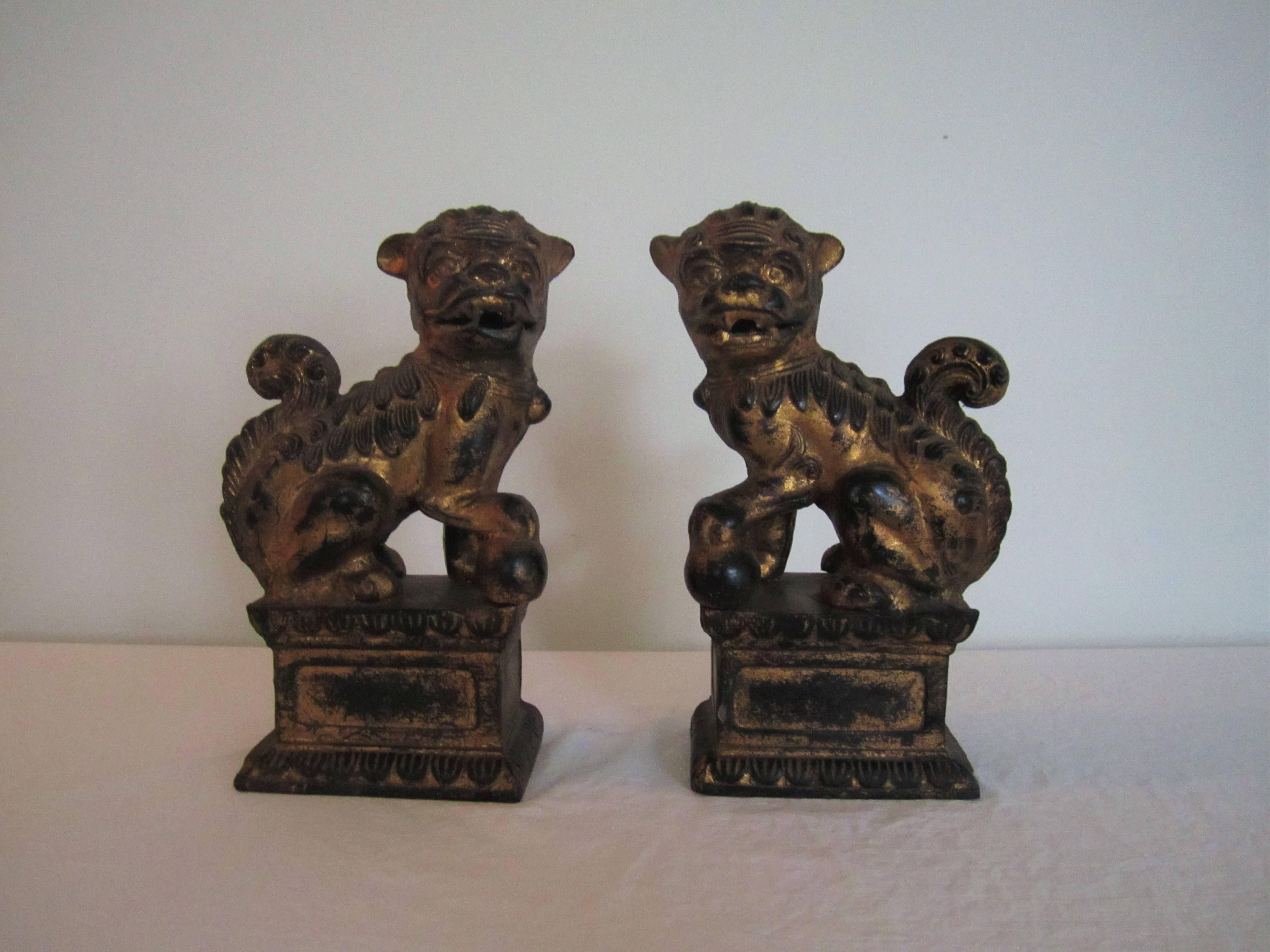 A substantial pair of vintage black and gold foo dogs made of cast iron. Can be used as bookends or stand-alone decorative objects. Measures 10
