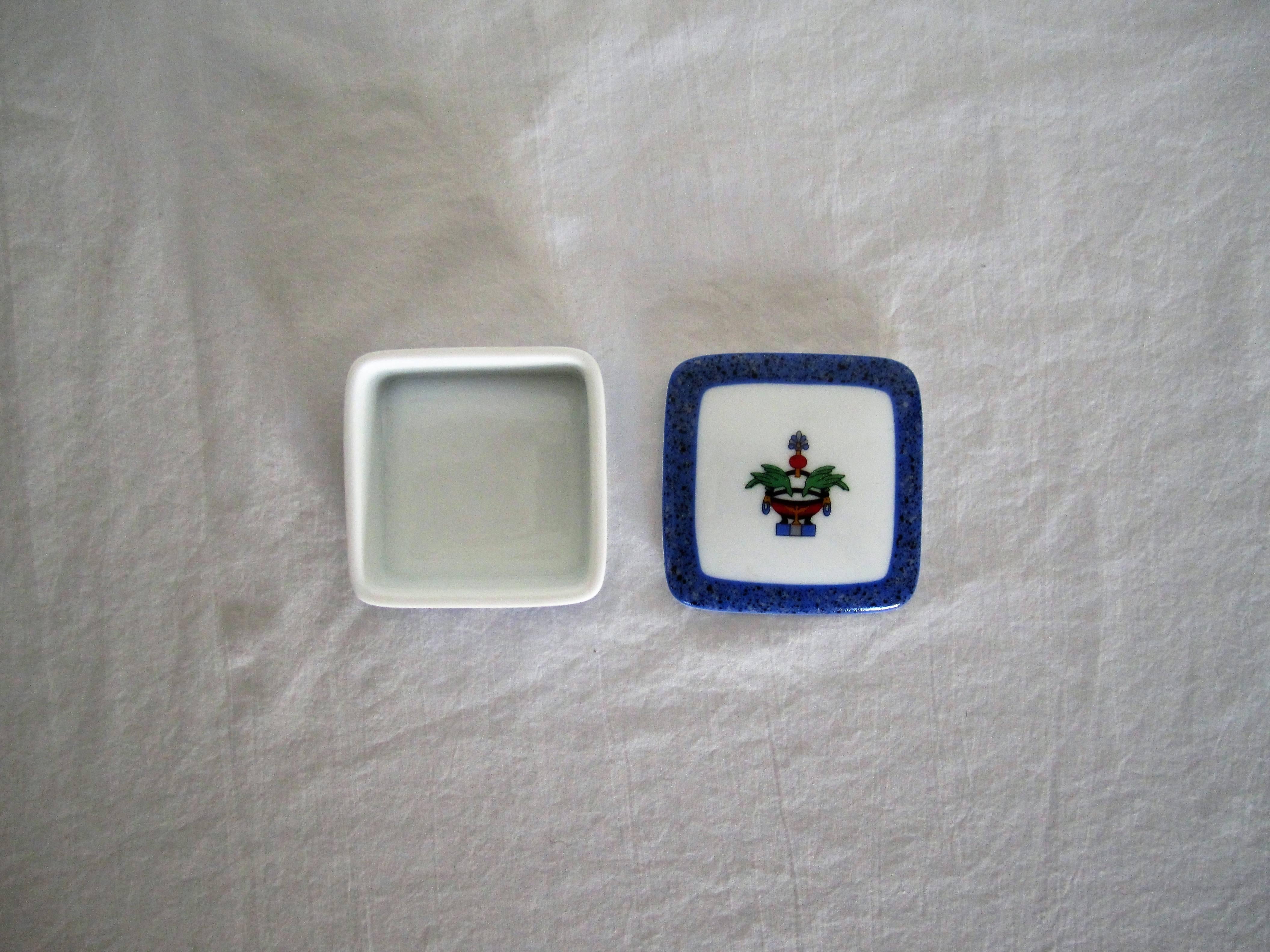A small Cartier porcelain box made by Limoges. Made in France. With makers mark on bottom as seen in image. A great vanity or bedside box for small items, i.e. earrings, cufflinks, etc. Very good condition, with no chips. Predominant colors include