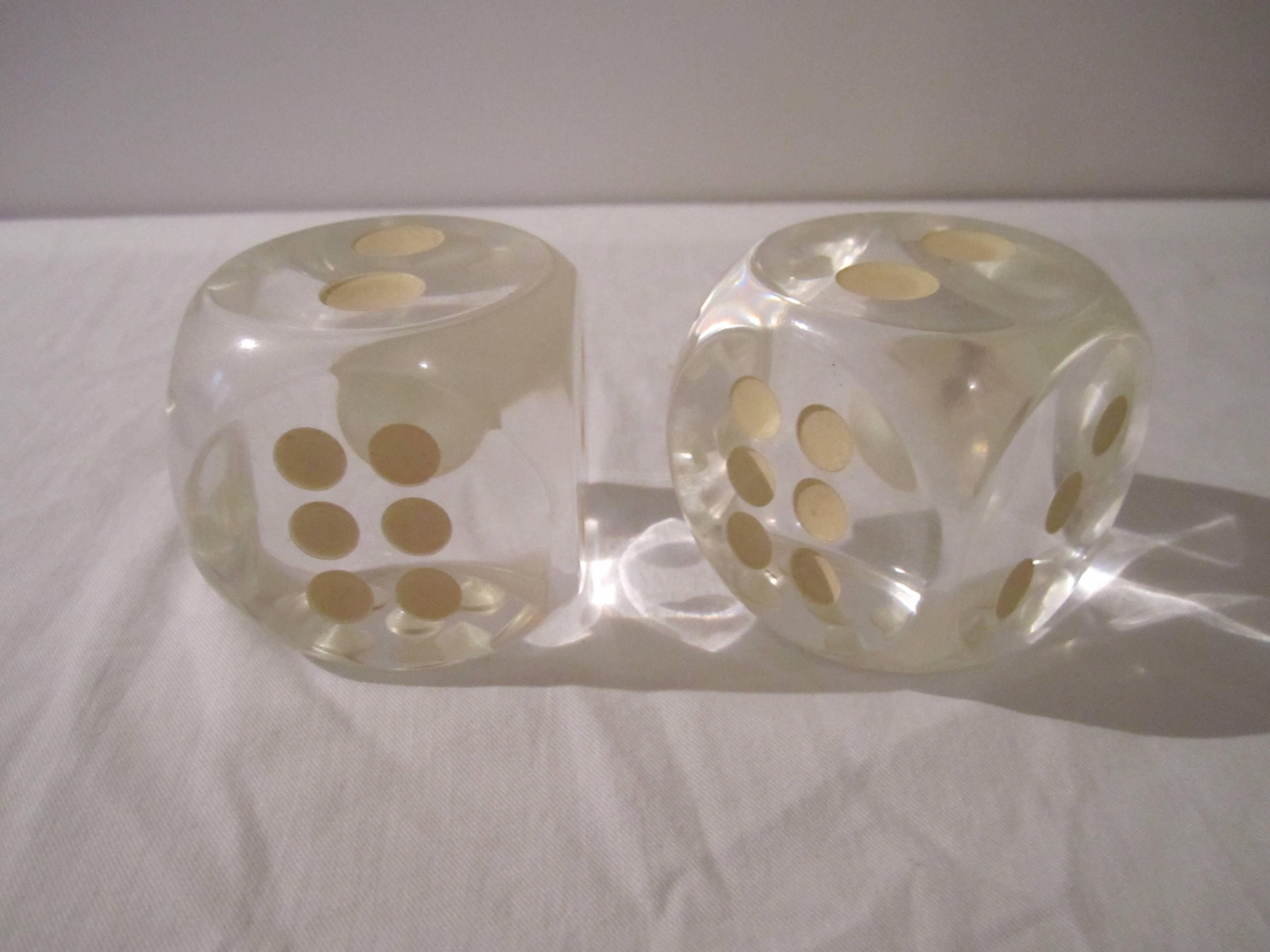 A 1970s modern pair of Lucite Dice. Great decorative piece(s) for a shelf, desk or table. Dice also glow-in-the-dark (temporarily) after exposure to light. 
