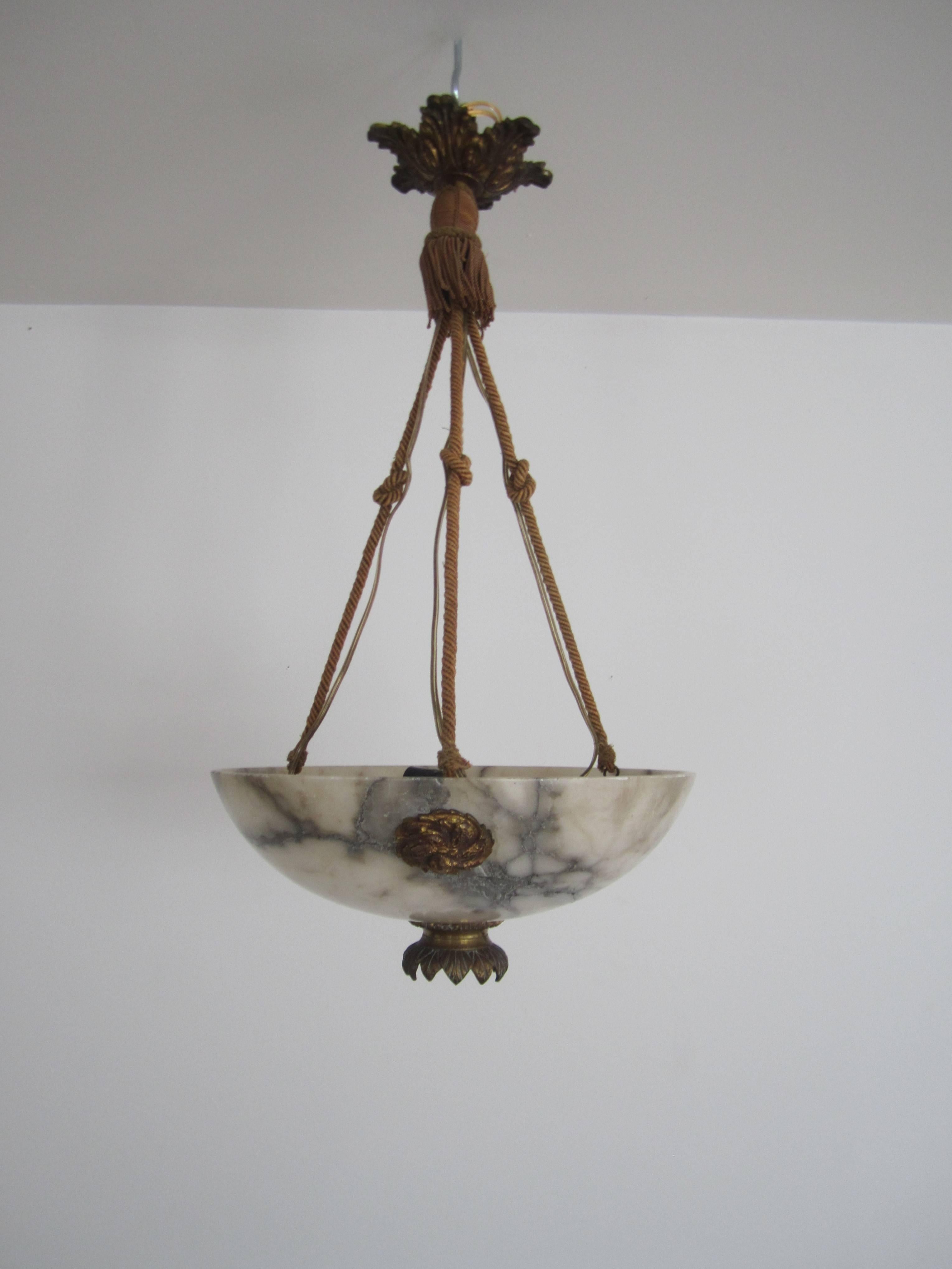 A stunning Mid-20th century French four-light alabaster marble and brass chandelier. Chandelier has a beautiful brass lotus flower detail at bottom of shade allows light to flow down (close-up see image #4.) There are three decorative gold gilt