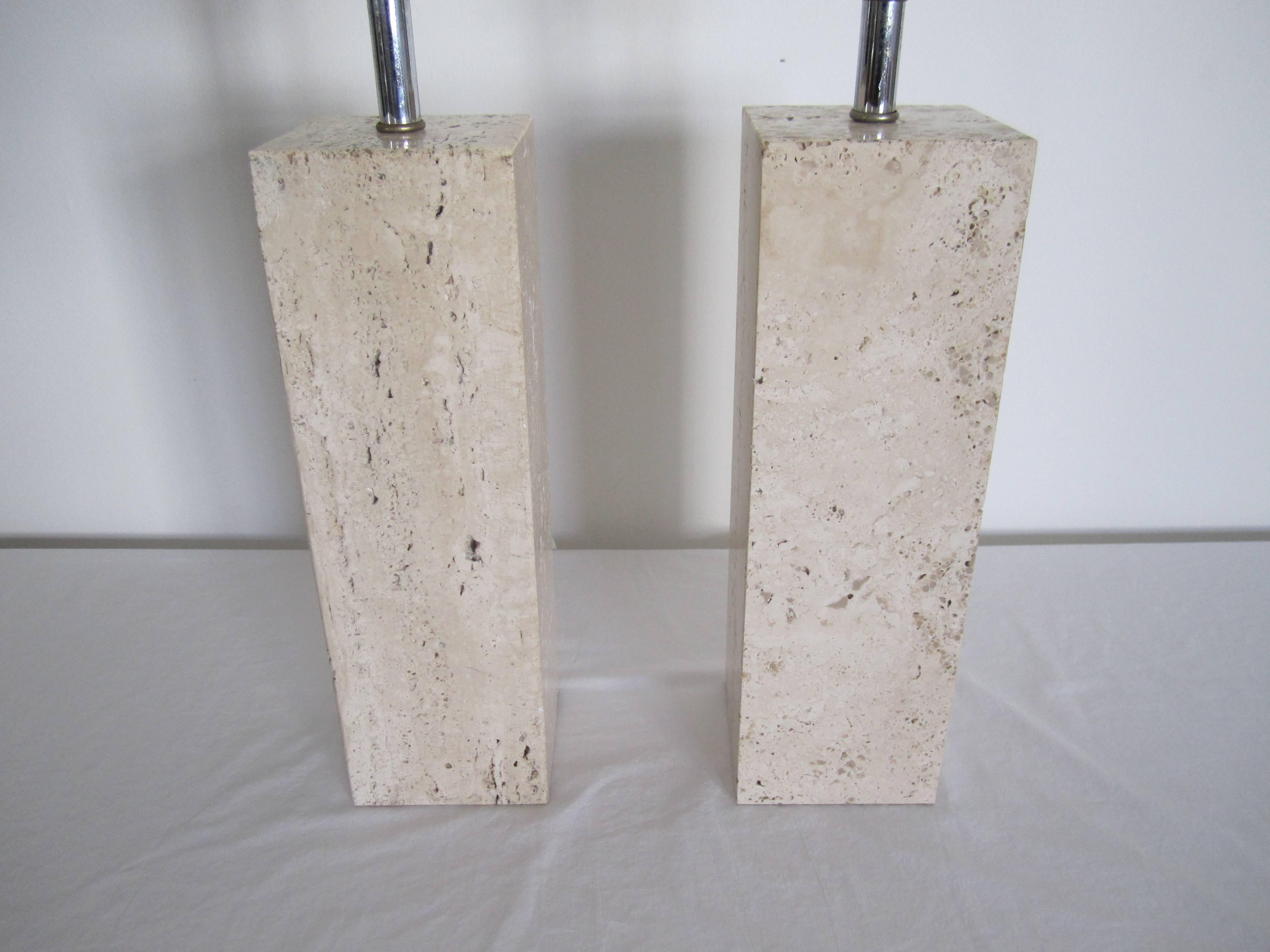 A pair of Italian Modern solid cream or sand colored travertine marble table lamps. Italy, circa 1960s -1970s. Shades included. 

Some additional measurements: 12 in H to top of travertine. 17 in. H to top of socket. 26 in. to top of finial. 

Pair