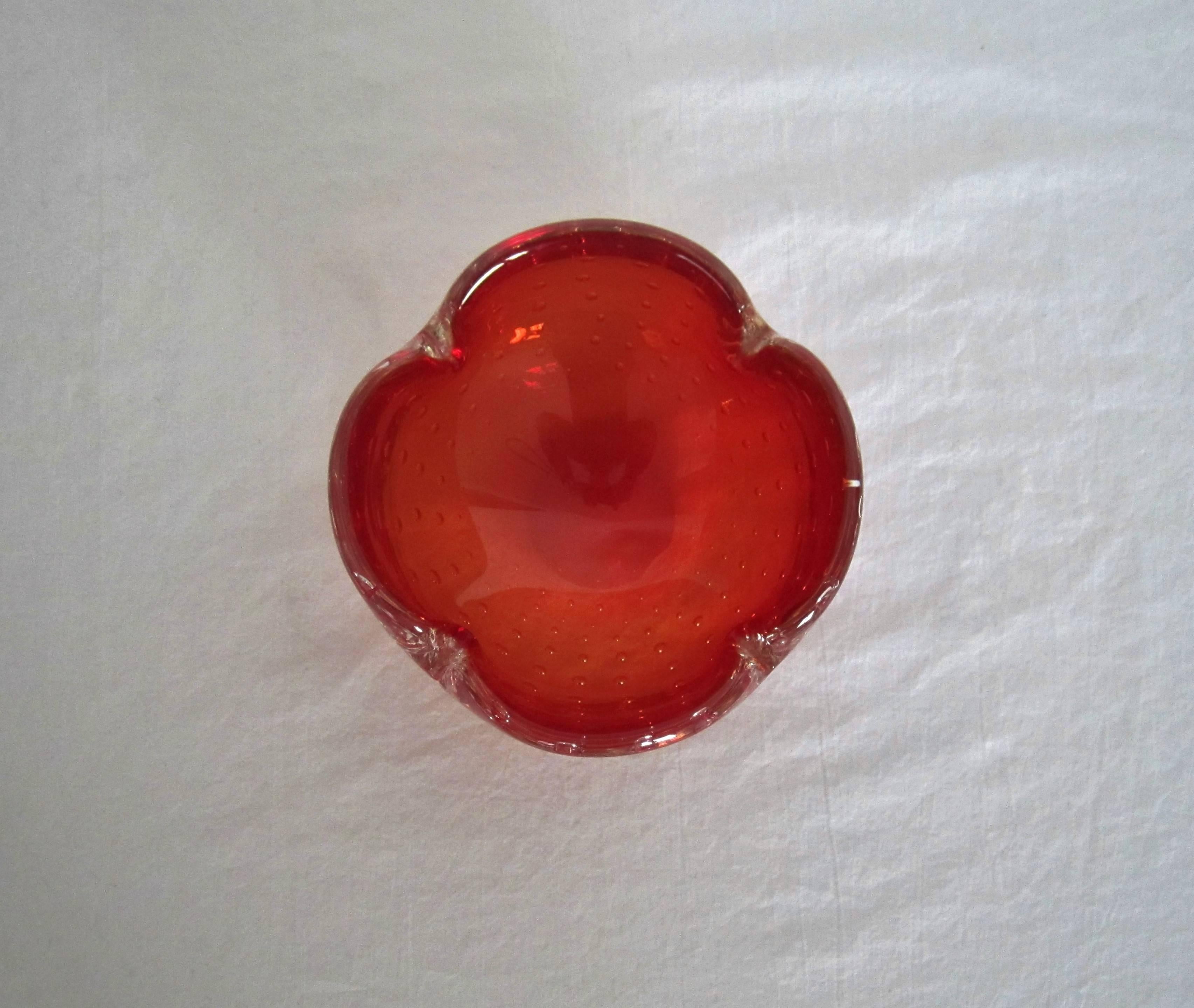 A Mid-Century small red Scandinavian Modern art glass bowl in a 'flower' or 'clover' shape with a controlled bubble design, from Denmark. Murano art glass candy shown in image #10 available separately. 


