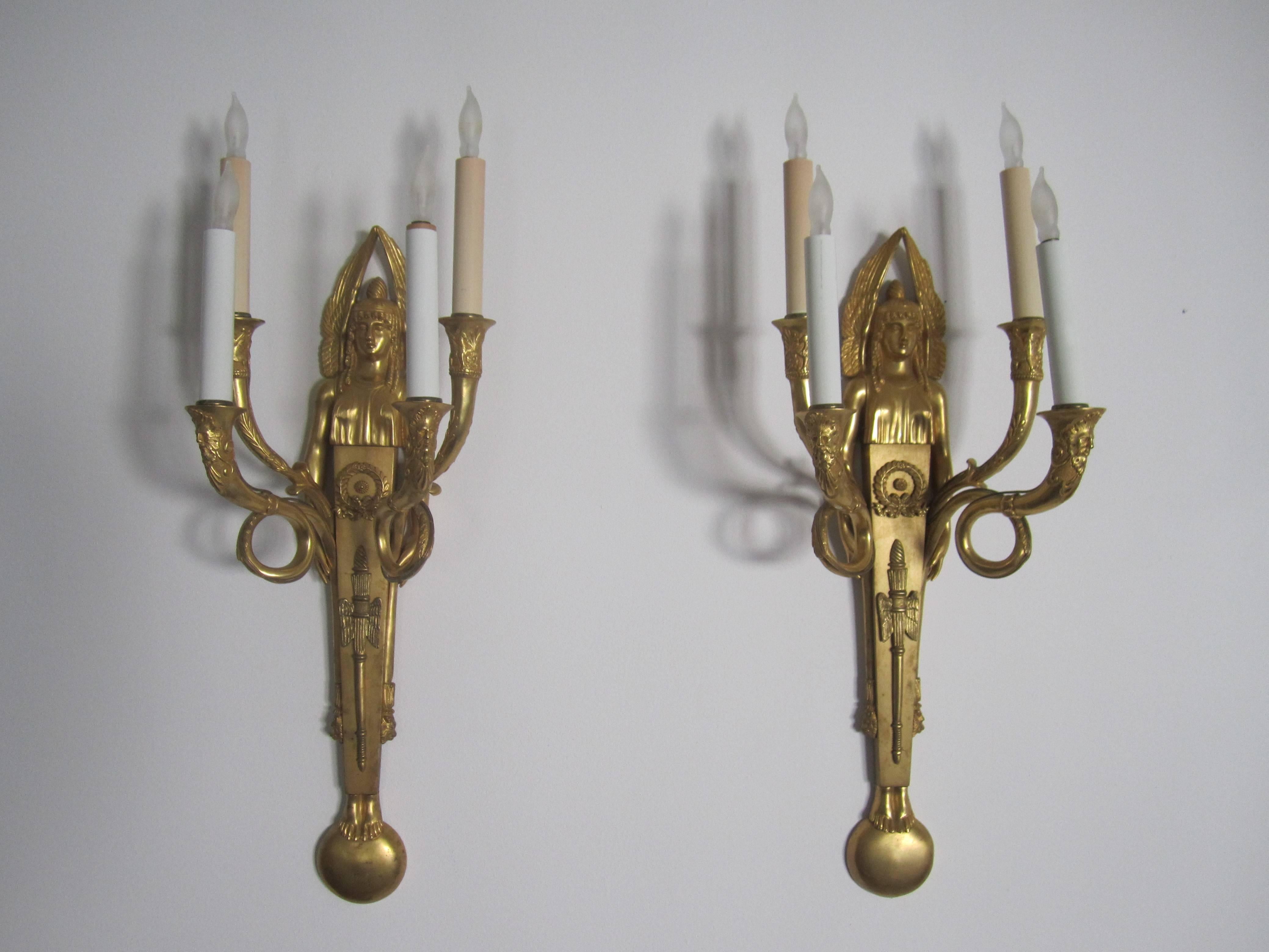 A gorgeous and substantial pair of Egyptian Revival Dore' bronze four-light wall sconces. Doré bronze is in excellence condition as show in images. Each sconce holds four lights. Pair is in working order for US electric. 

Measurements include: 24