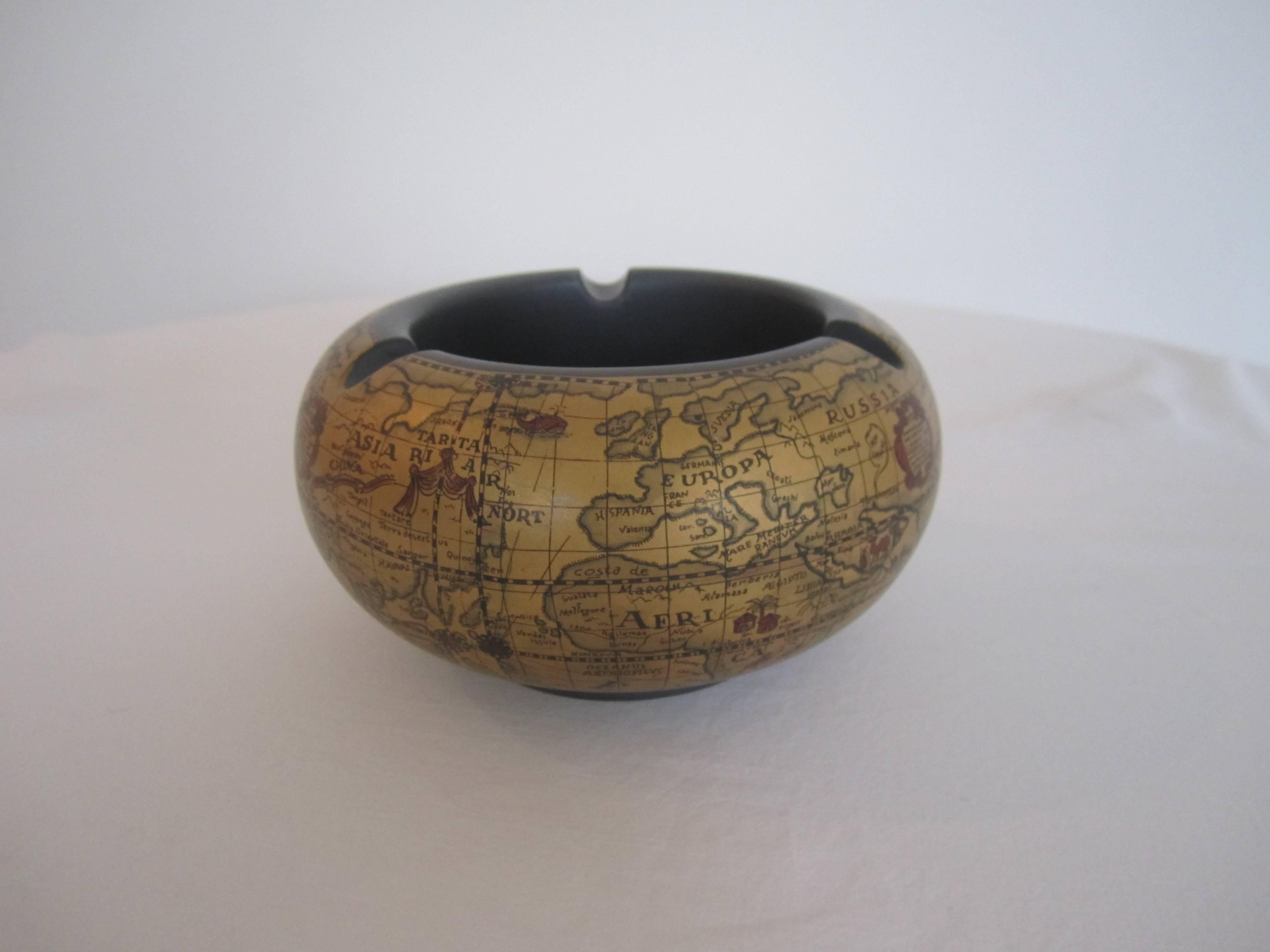 A vintage world globe ashtray or bowl, gold on the exterior with a world map and a dark grey interior. Marked, Made in Florence, Italy. Item available here online, and by request, can be made available at my showcase space in the Showplace Antique +