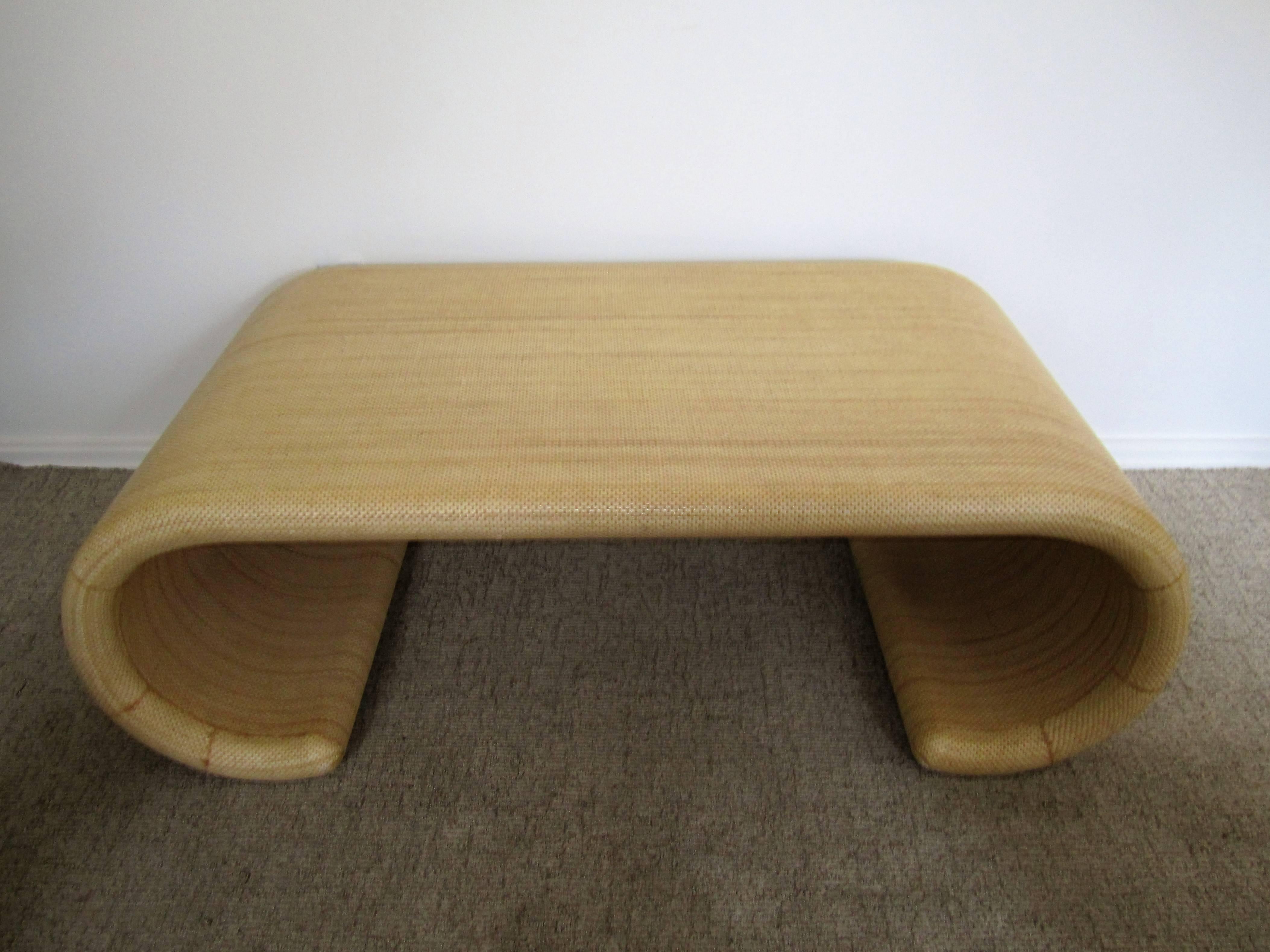 A Modern scroll coffee or cocktail table in the style of designer Karl Springer. Table is wrapped in a 'sand' or 'wheat' colored nylon grass cloth material, circa 1980s - 1990s.

Table is available here online. By request, table can be made