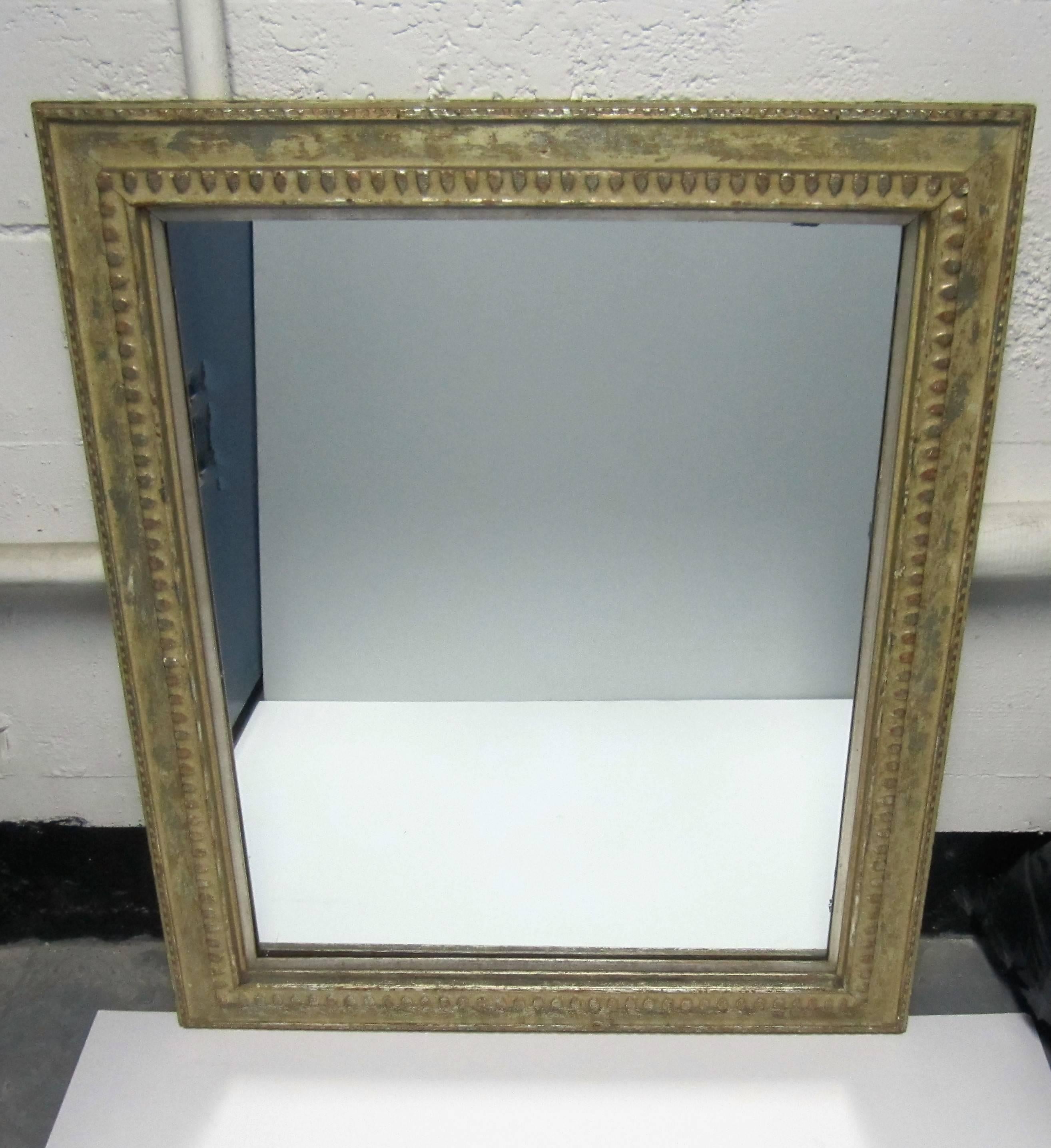 A beautiful vintage wood and metal distressed framed wall mirror. Frame is a creamy antique white - antique beige color with hints of silver (the metal) showing through; Frame has beautiful details/design; there is also a second frame, a small thin
