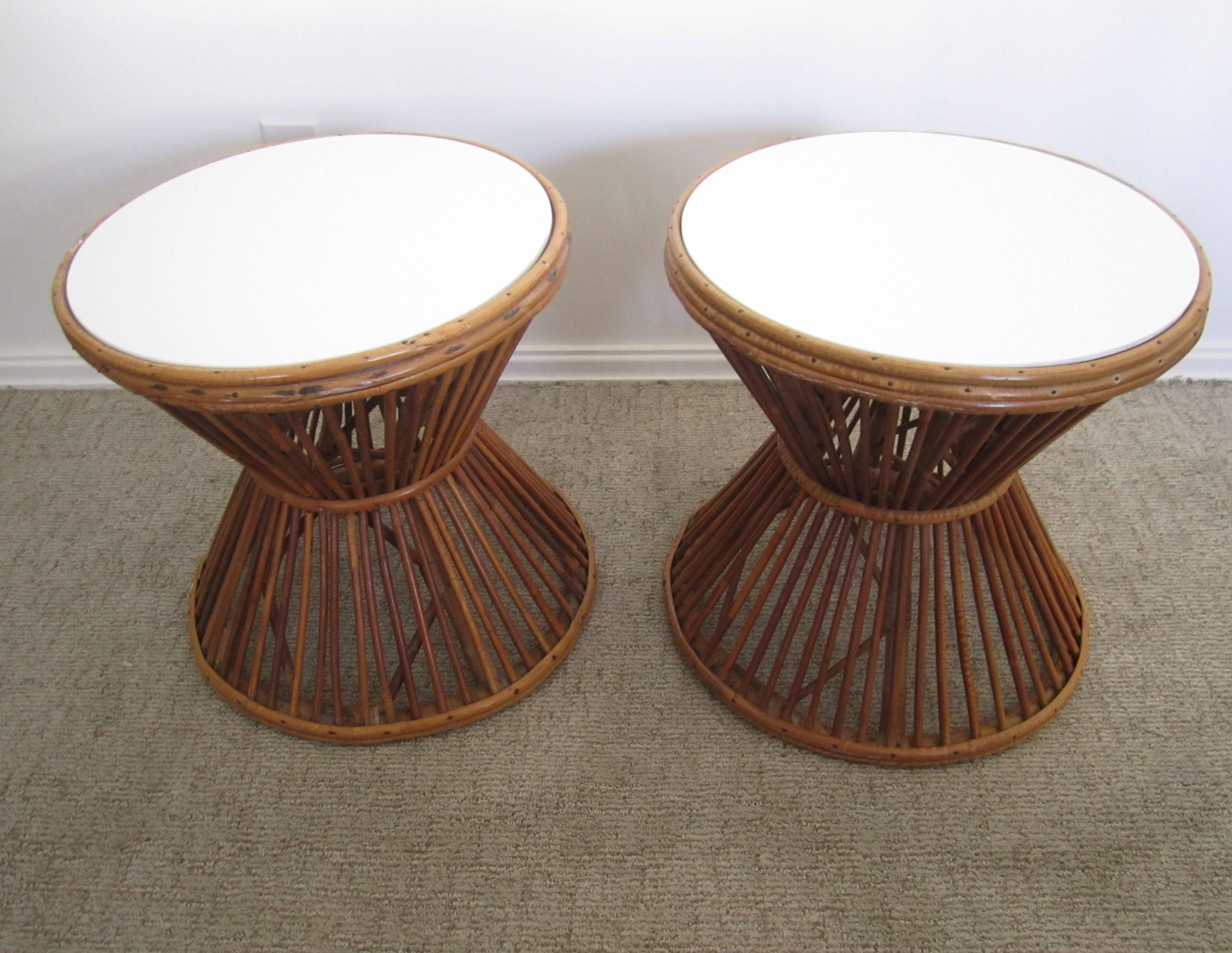 A vintage pair of Franco Albini (1905-1977) style rattan end or side tables with white opaque glass tops. Tables have an 'hourglass' design with inset white opaque round glass tops. Tables can be used as side, end, or cocktail tables. Circa, 1960s -