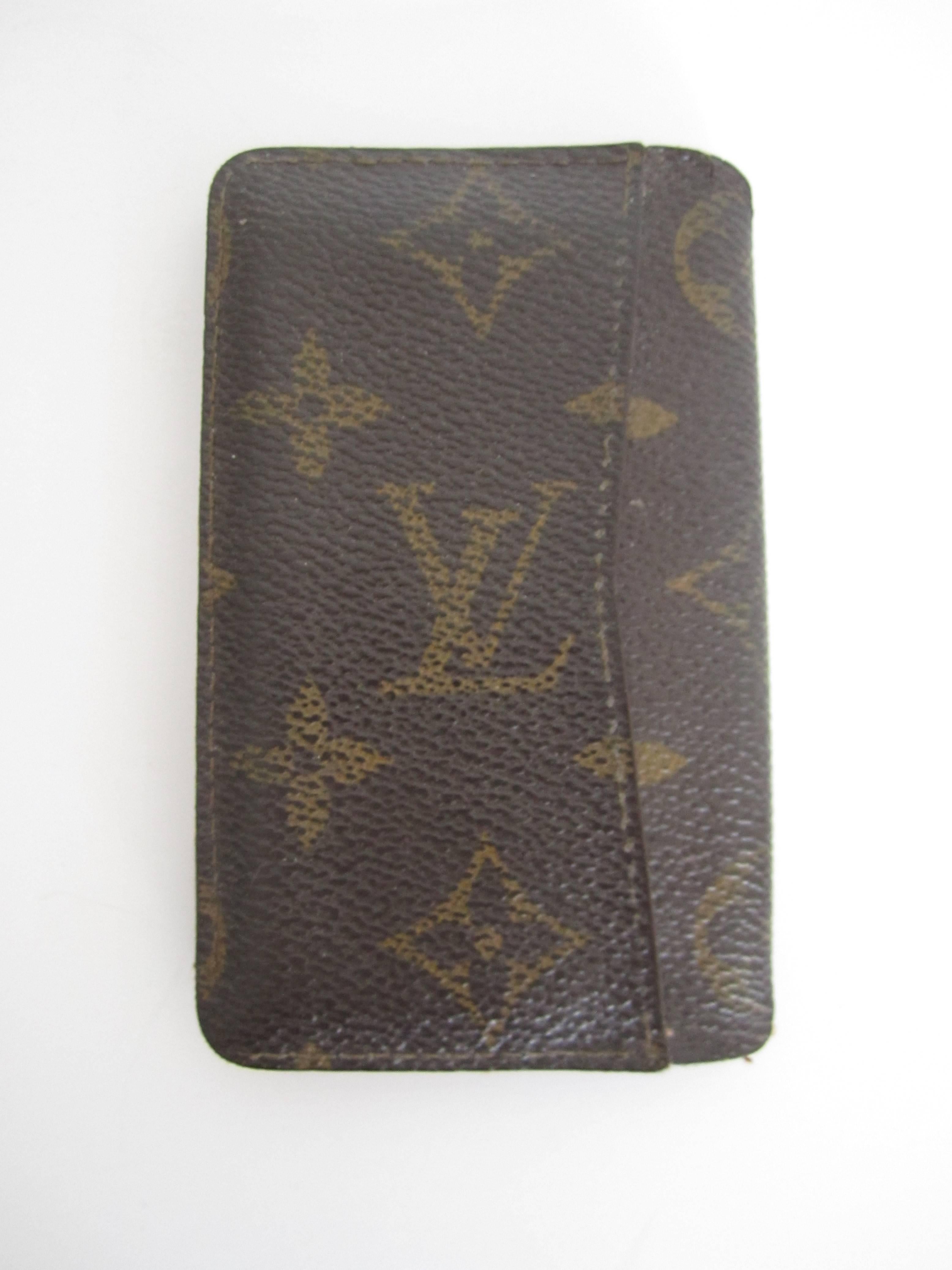 A vintage authentic Louis Vuitton credit card or business card holder case in the classic, iconic monogrammed and leather pattern, circa 1992. This LV Louis Vuitton card holder features one area on the outside cover for cards and two areas on the