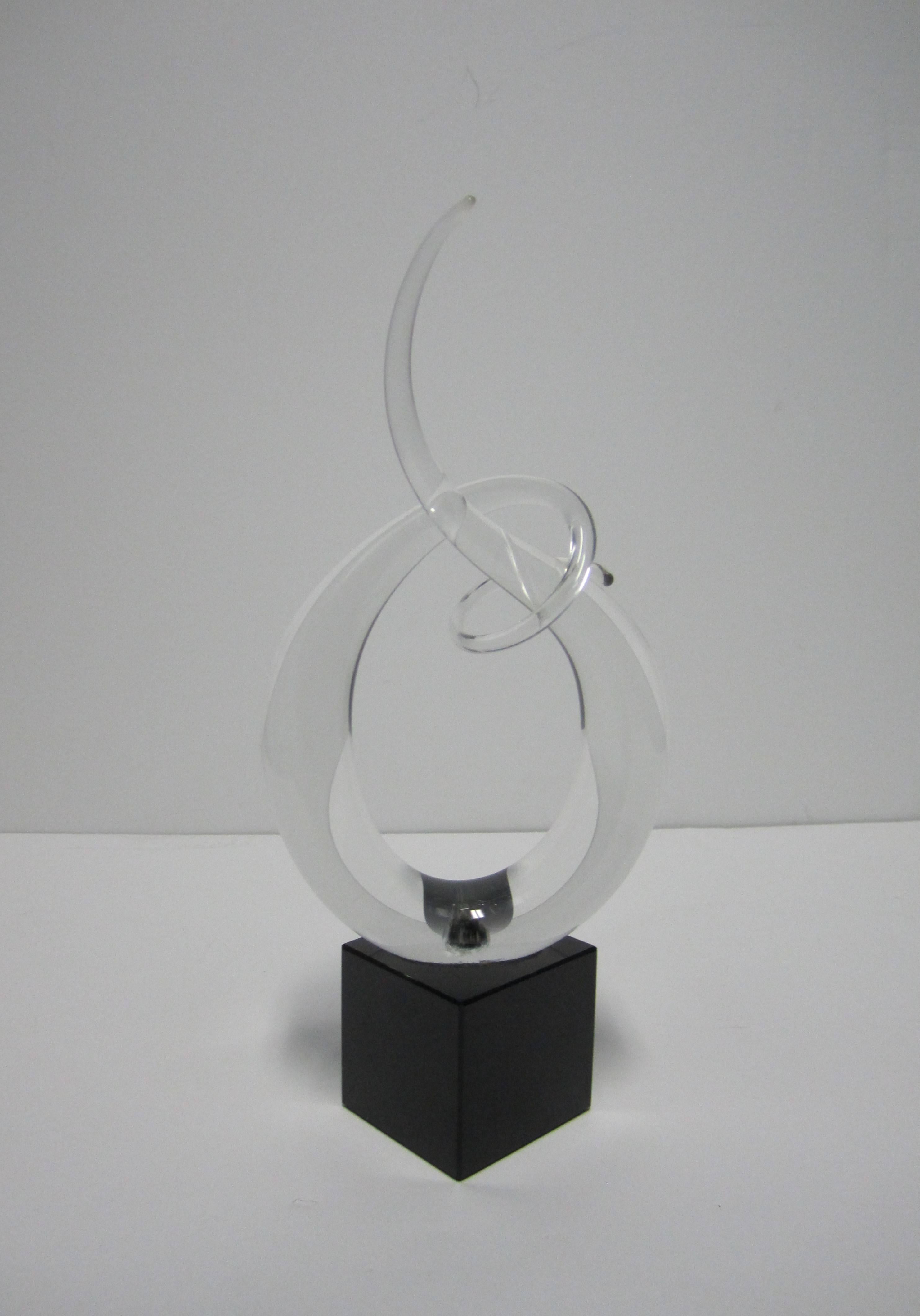 A signed Post-Modern or Modern style abstract clear Italian Murano art glass sculpture on a solid black marble base. One single piece of smooth clear Murano art glass formed into a twist, loop, or curl design. Signed on bottom as show in image #10. 