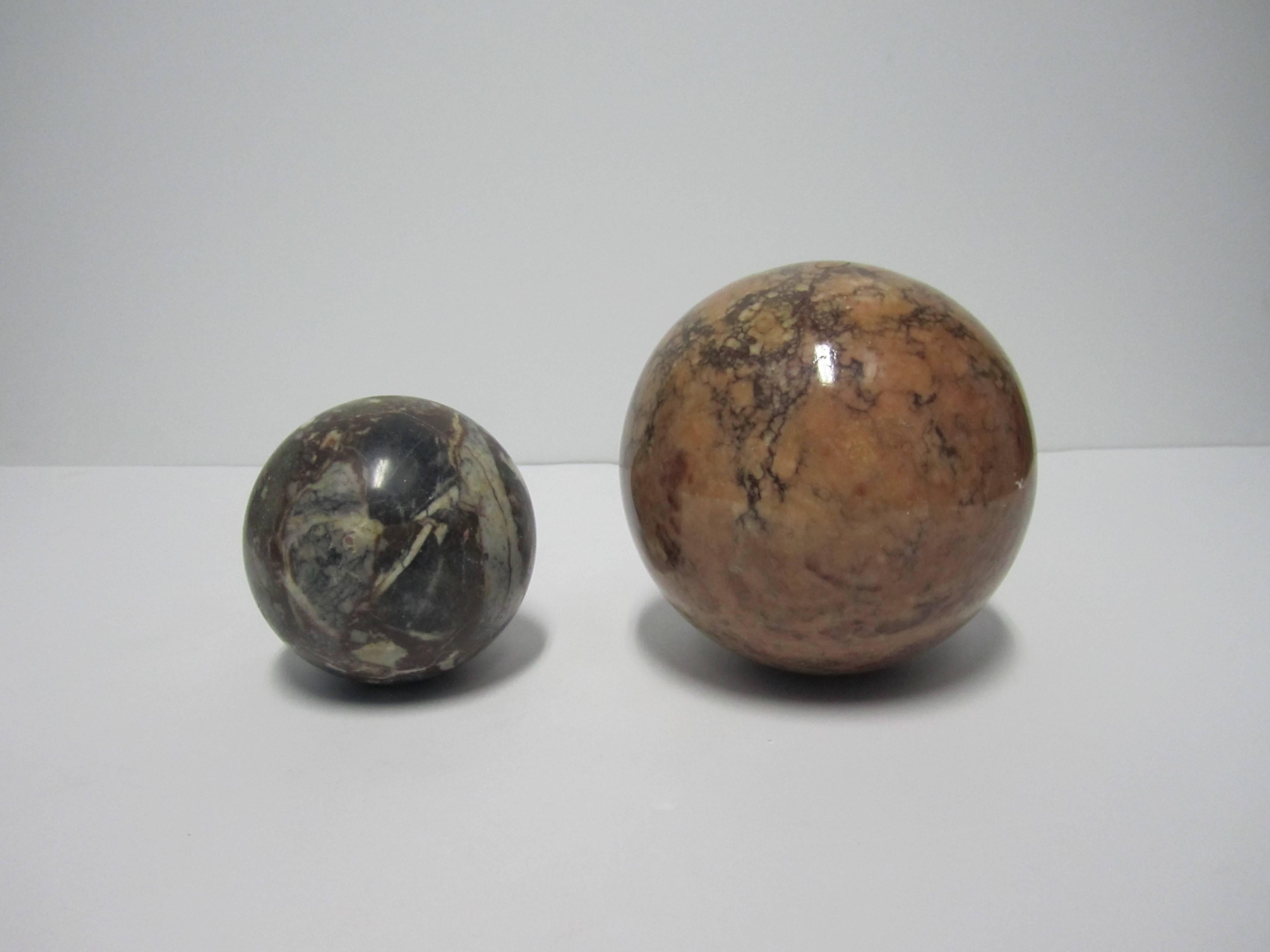 A vintage pair of Modern marble spheres, circa 1970s. Colors include blue, green, white, salmon pink, cream, and dark red. Measurements: 4 inch diameter and 6 inch diameter. Pair available here online. By request, pair can be made available by
