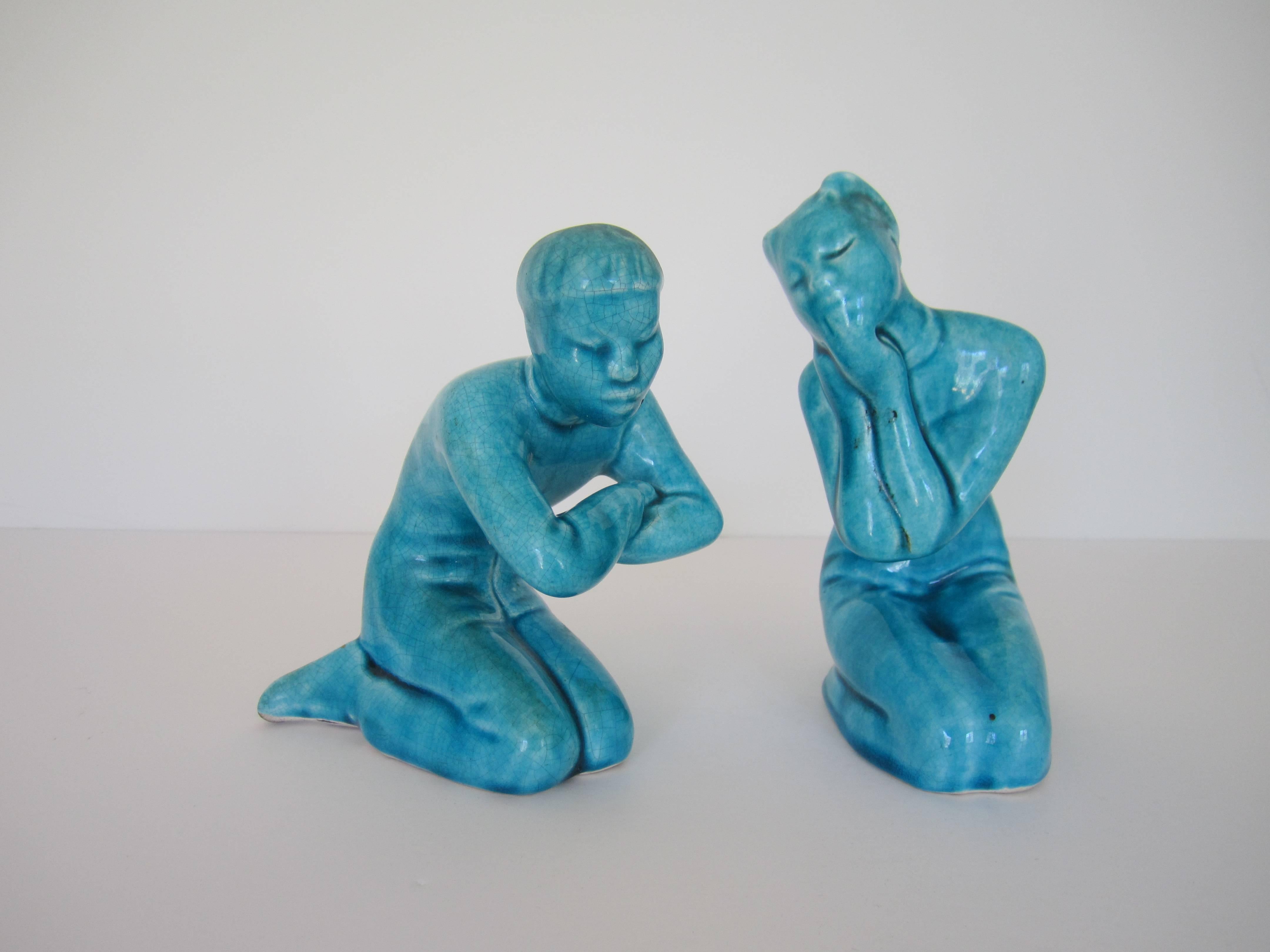 A pair of mid-20th century turquoise blue Asian male and female figural porcelain ceramic sculptures with 'crackle' design and glazed finish. Height is approximately 6.25