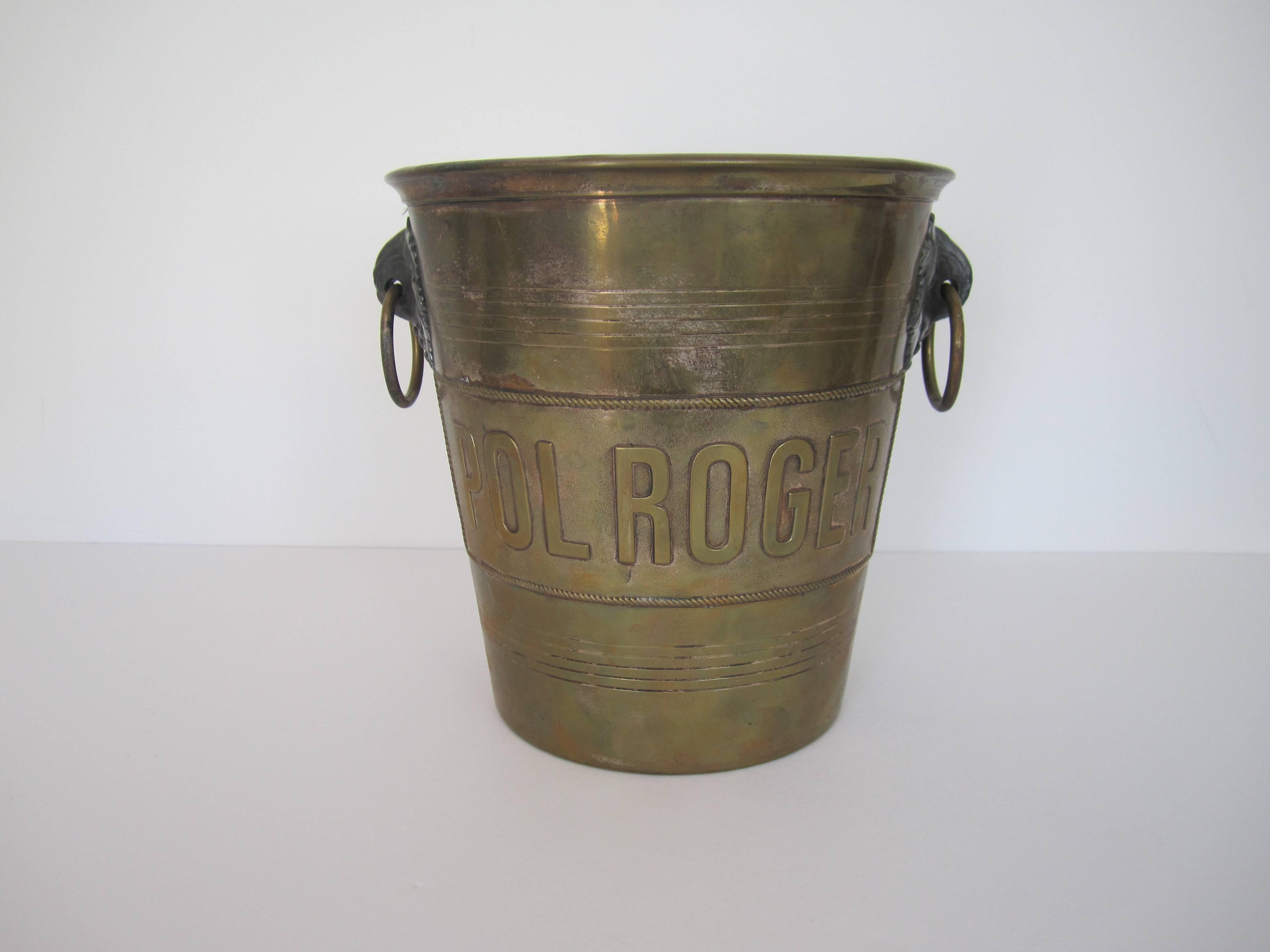 A vintage brass 'Pol Roger' Champagne ice bucket, from Paris. 'Pol Roger' across front with loop handles and grape leaf design on sides. Made in France. Item available here online. By request, item can be made available by appointment to the Trade