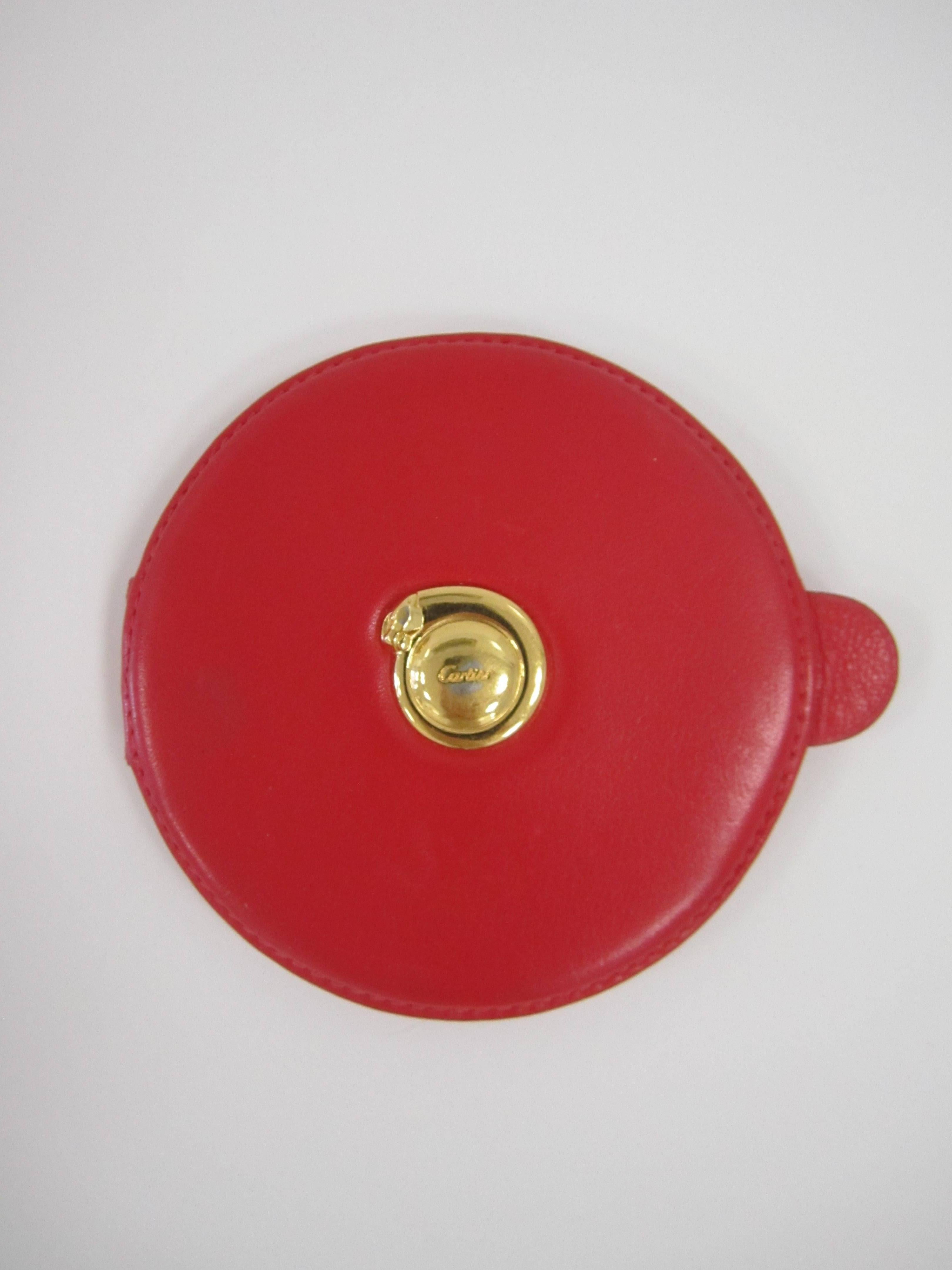 A vintage red leather Cartier compact mirror with gold-tone iconic panther cat on front. With maker's mark's 