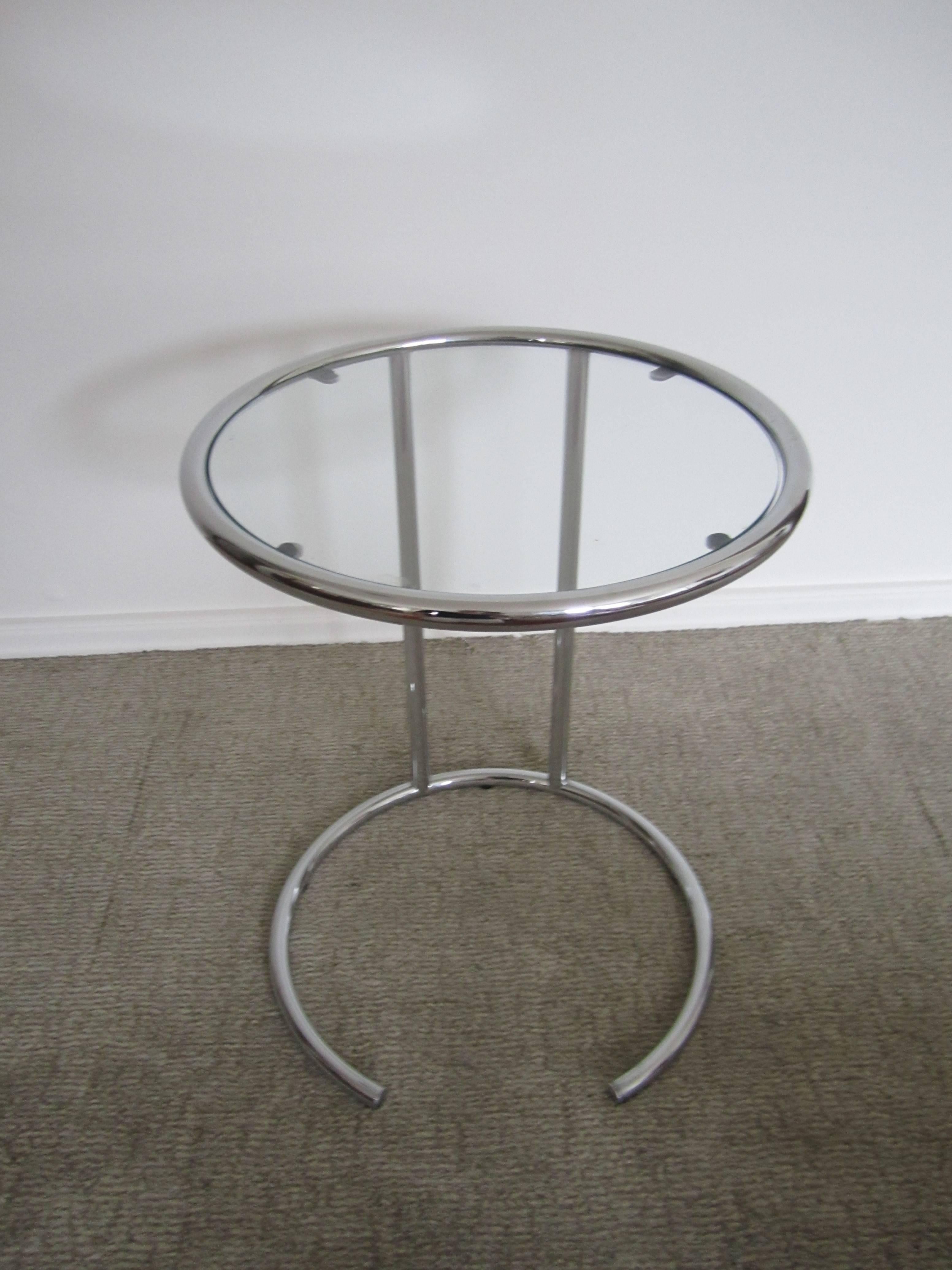 A vintage modern round chrome and glass side table, marked "Made in Italy" on bottom as show in image. Circular top supported by a semi-circular base. Circa 1970s. Measurements include: 21" h x 14.5" diameter. Item available here
