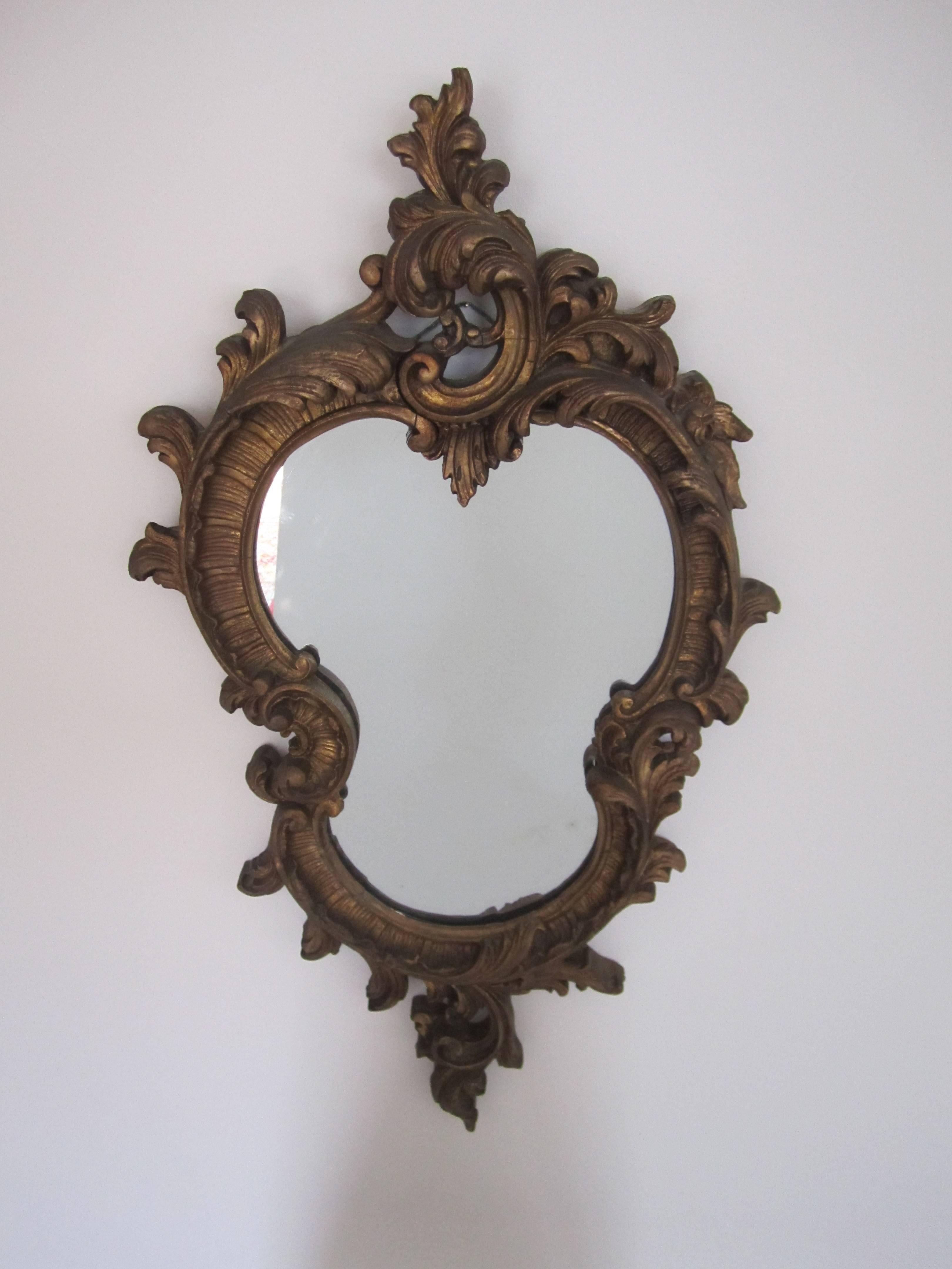 A beautiful Italian vintage carved giltwood wall mirror in the Baroque style, circa Midcentury - Late 20th Century.

Measurements include: 31
