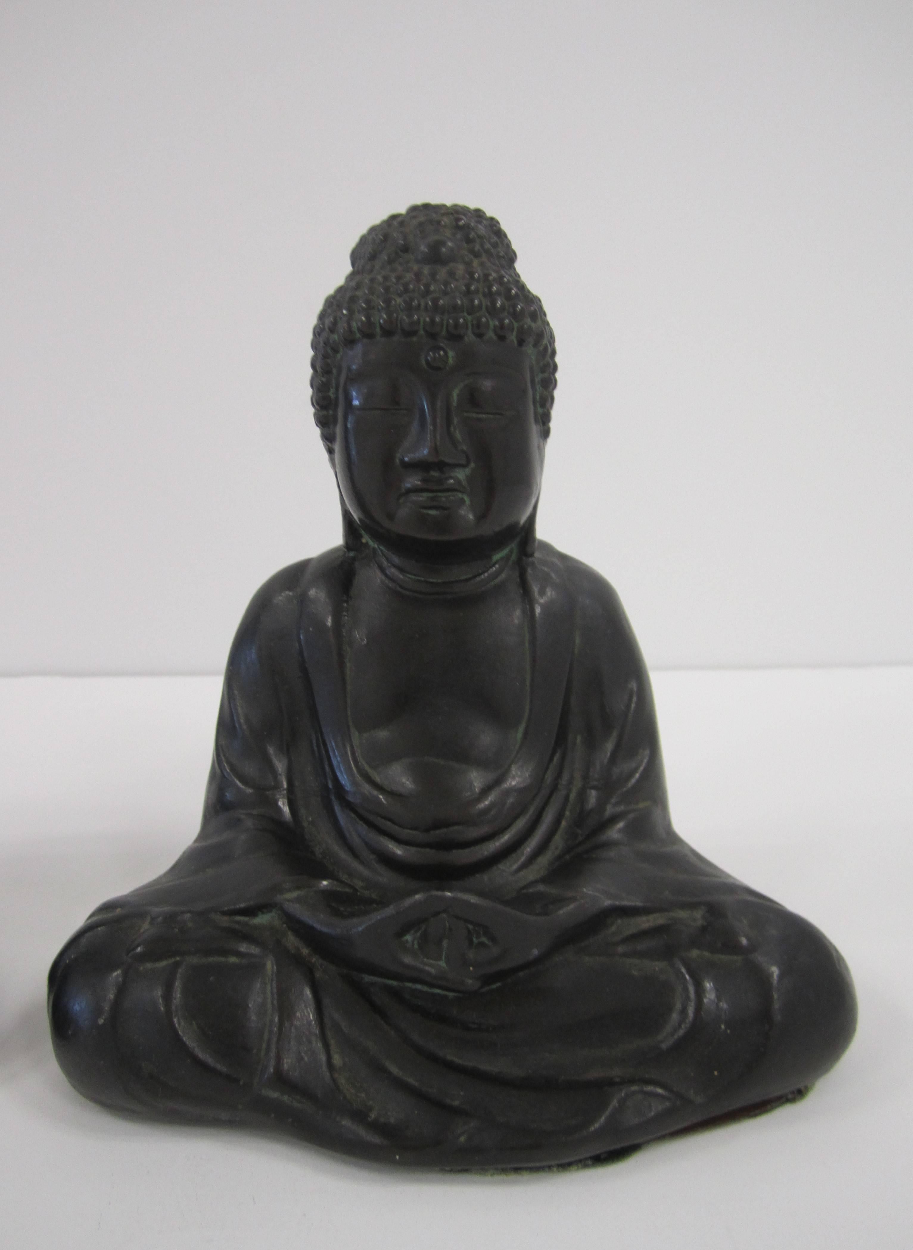 A special pair of Buddha bookend sculptures in prayer position, in an ebonized metal. With maker's mark on side, 