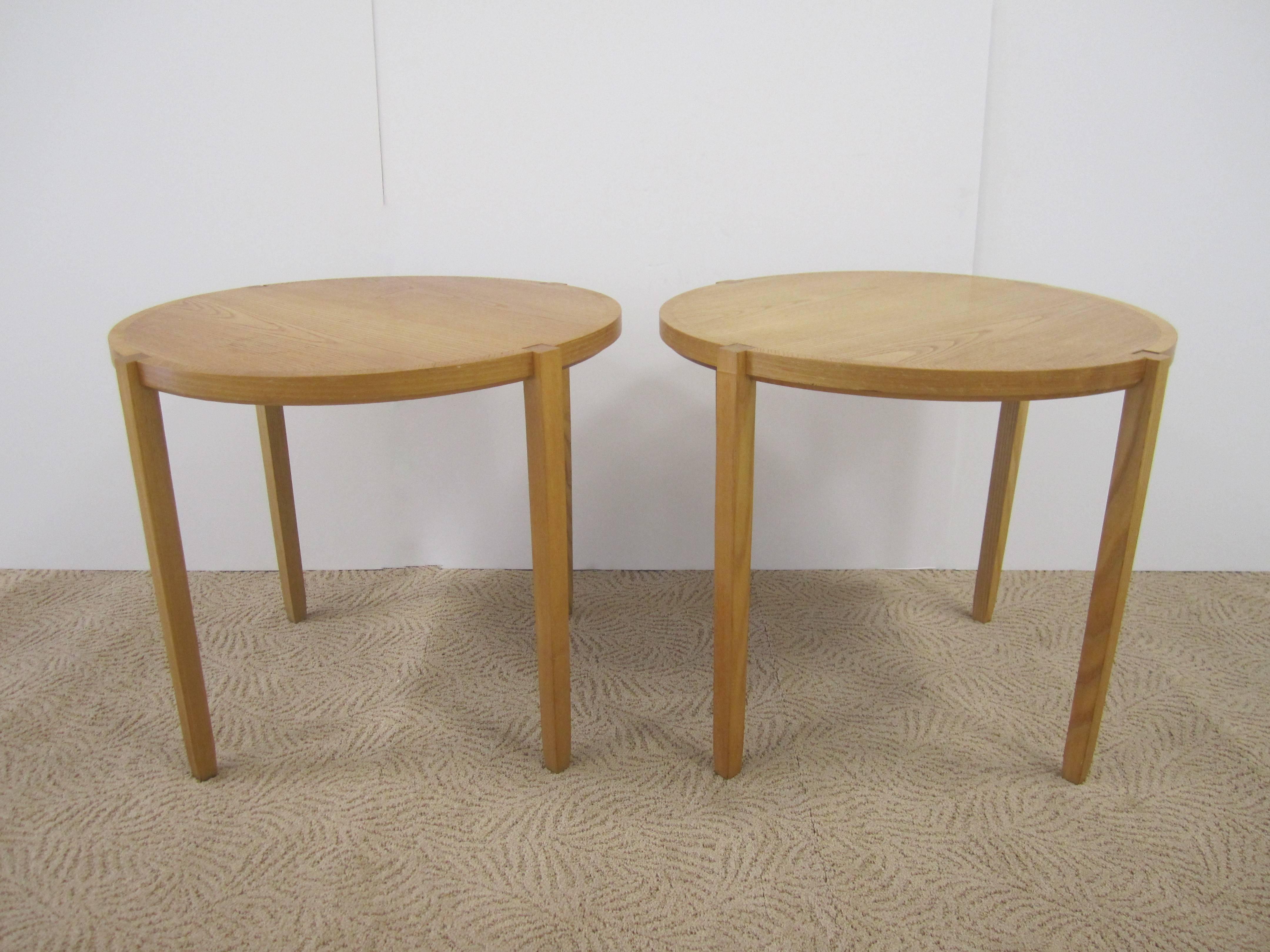 A pair of round end or nightstand tables by designer Timothy Defiebre for Brickel Associates. Oak tables are in an 'ash' finish with a thin tapered leg. With maker's mark and designer mark as show in image #10. Pair available here online. By