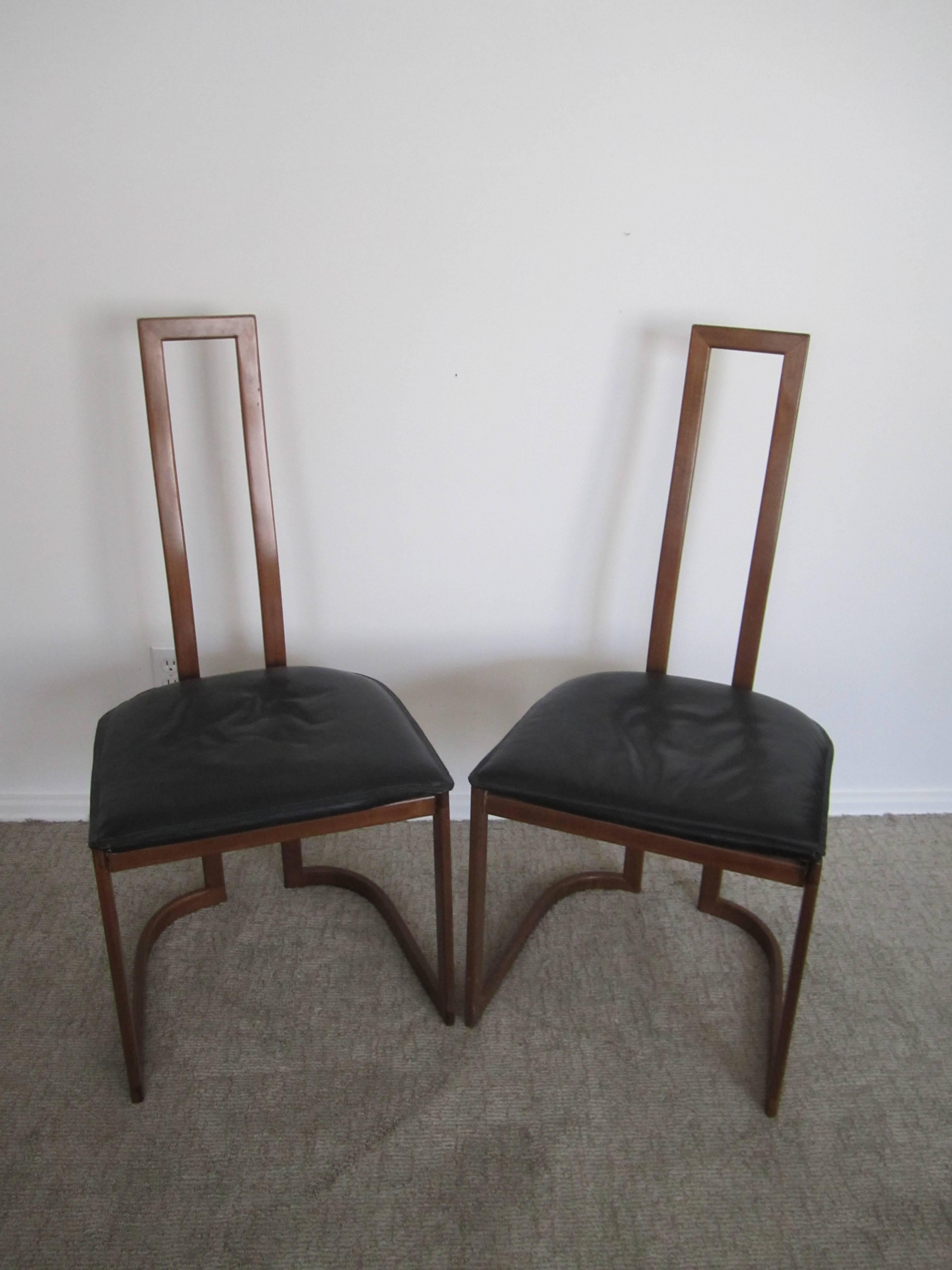 A vintage pair of Modern style Italian side chairs with black textured faux leather upholstered seat cushions, circa late 20th century.  

Measures 40 in. H. 

