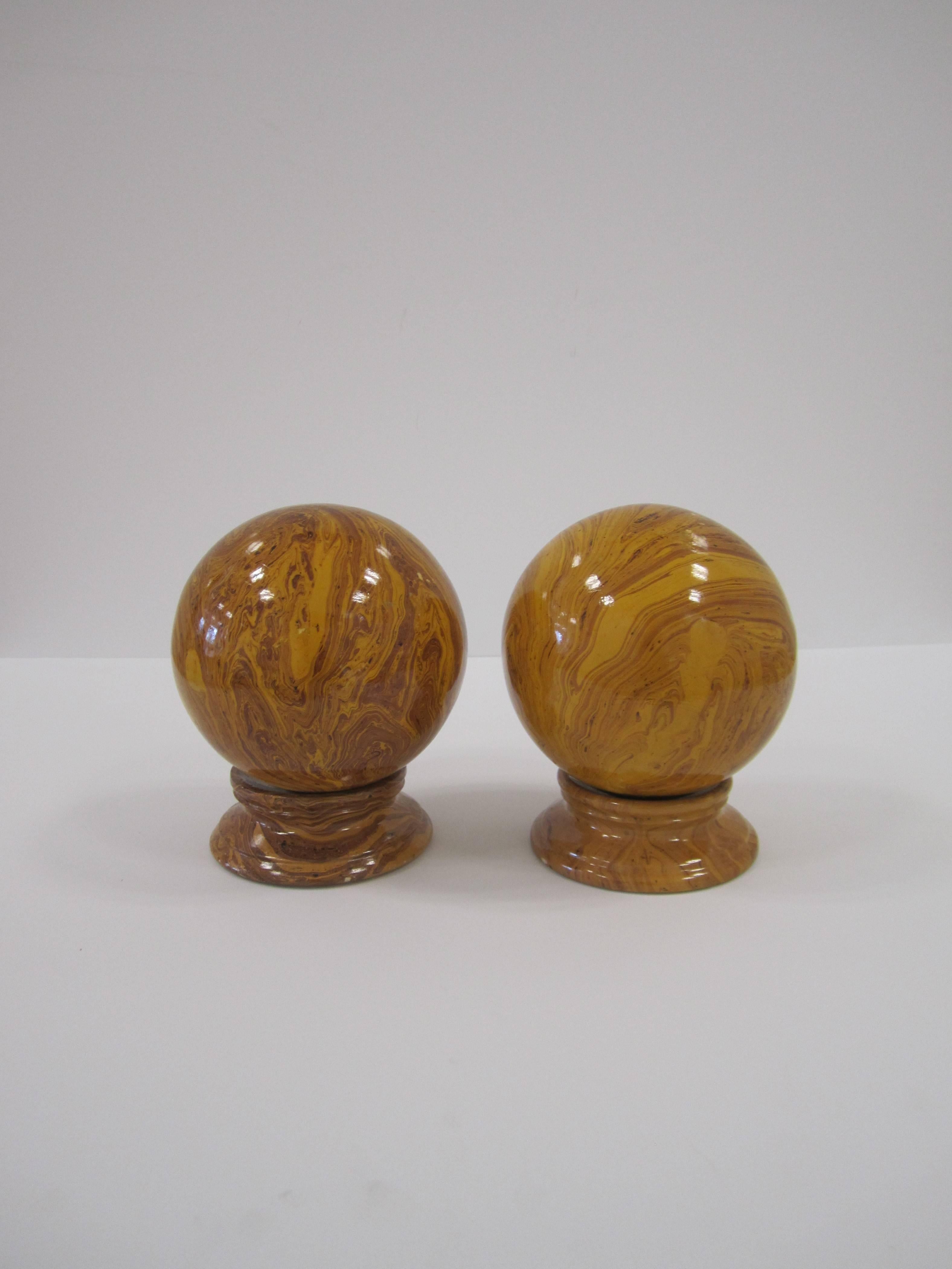 A pair of Italian ceramic marbleized glazed decorative round globe ball spheres garnitures on pedestal bases, circa late-20th century, Italy. Well made with a beautiful marble pattern, covered with a light glaze. Colors include swirls of deep
