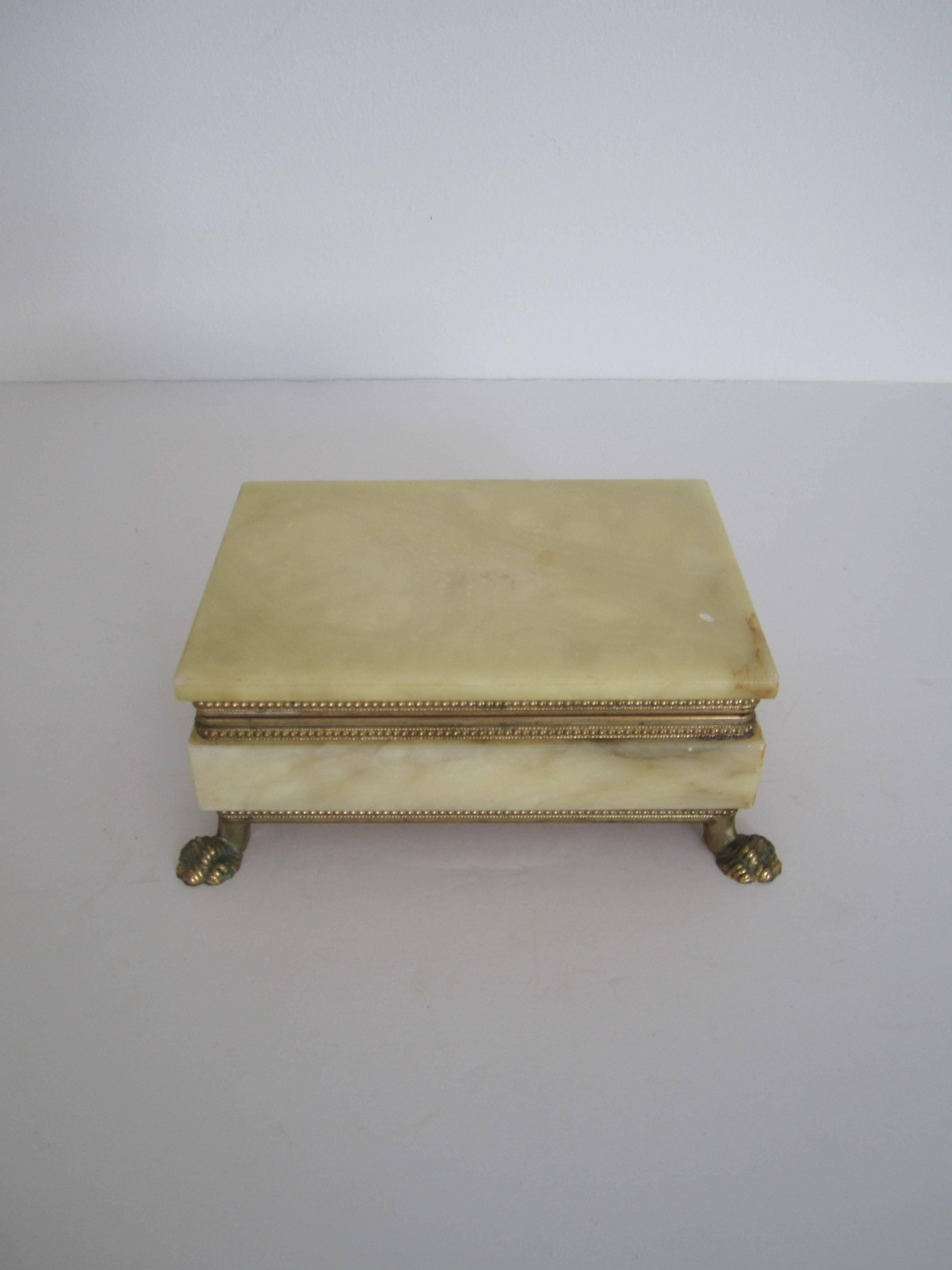 A Mid-20th century Italian alabaster marble and brass hinged box with paw feet, in the Regency style, Italy. Marked on bottom of box 'Made in Italy' as show in image #11. Alabaster marble is a cream color hue with a brass frame and hinge and