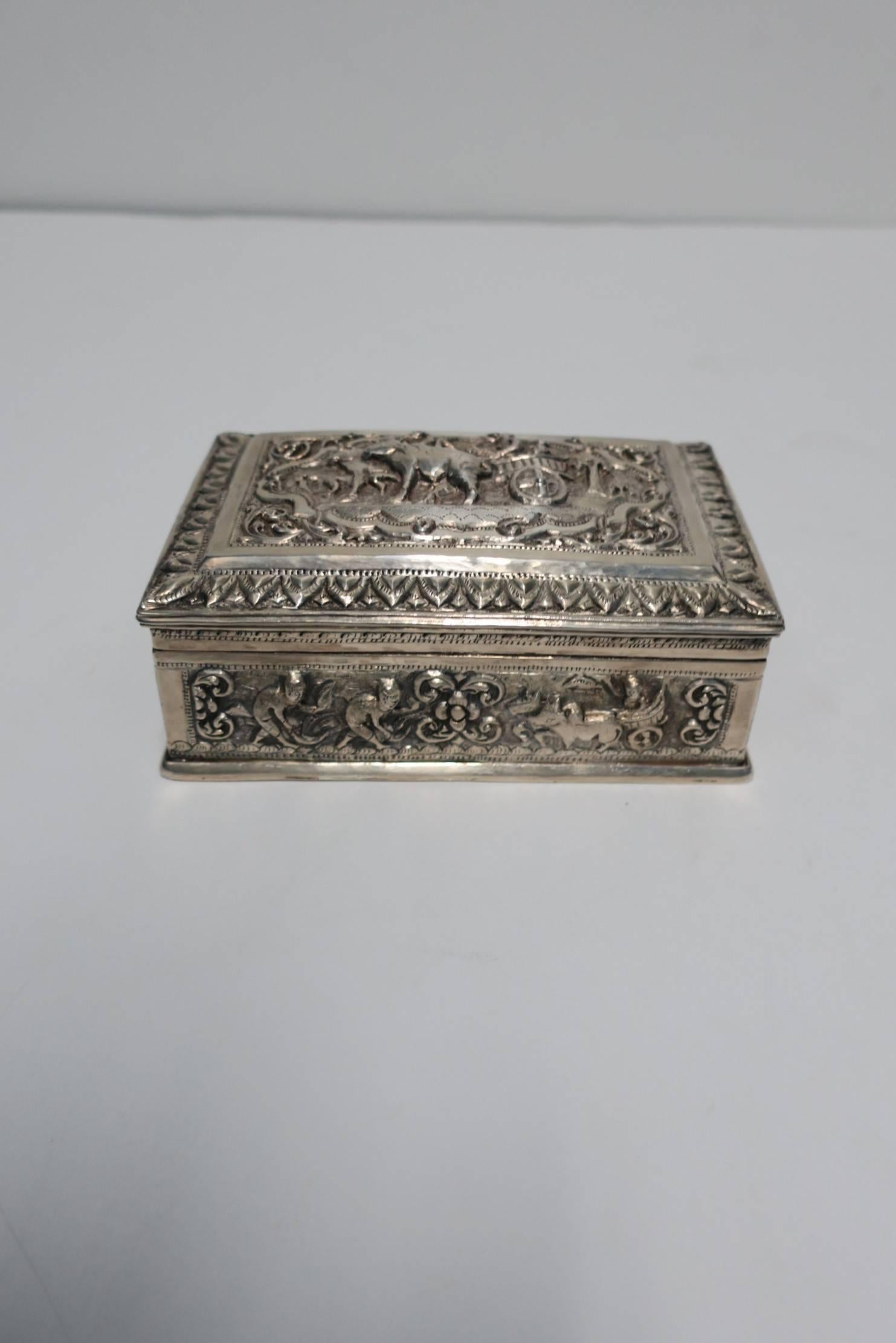 A beautiful vintage substantial decorated sterling silver hinged box with wood interior from Burma. Carved sterling sliver decoration include water buffalo, elephant, foliage, boat with fisherman, a carriage or rickshaw. Marked 