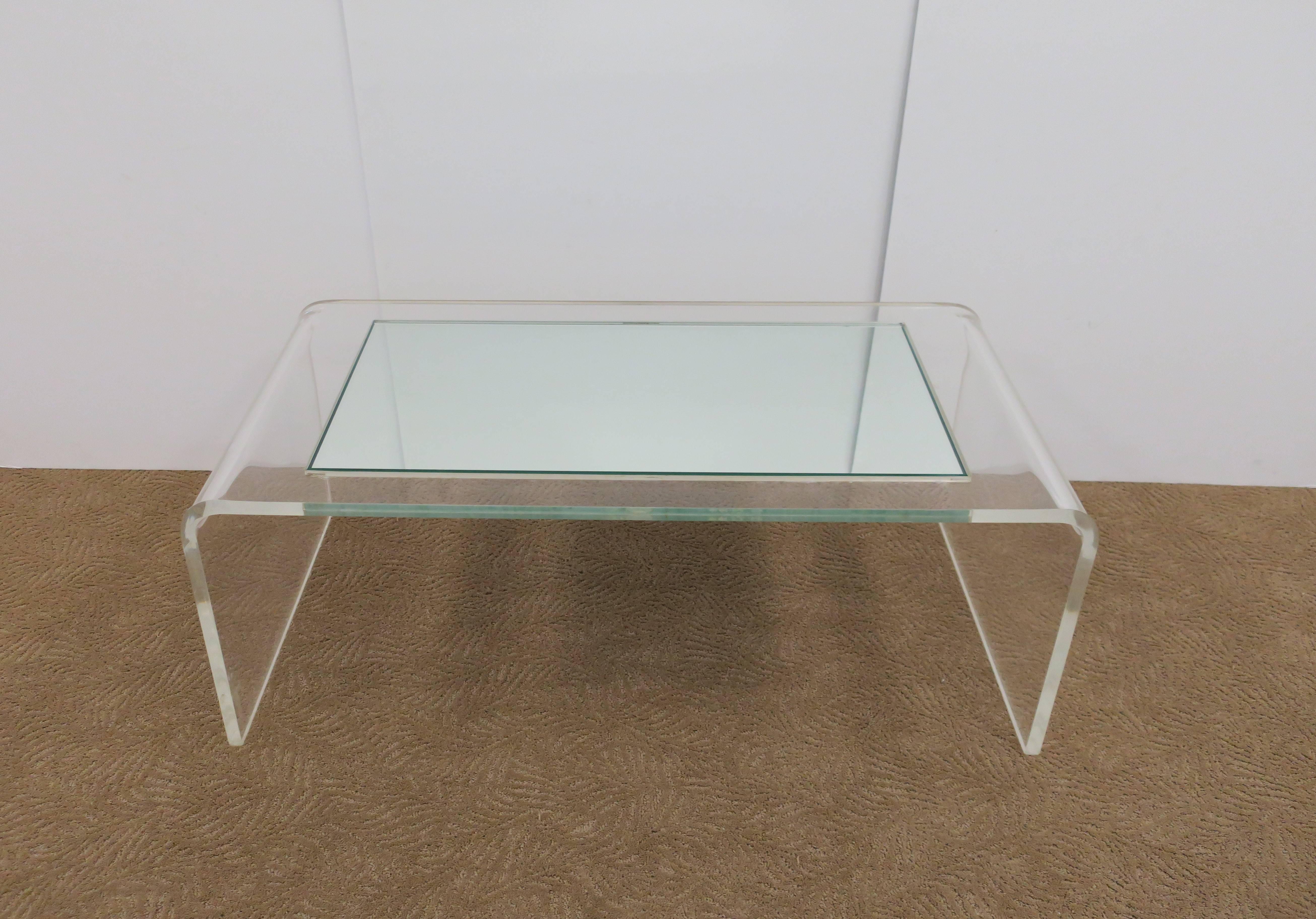 A '70s Modern Lucite and glass mirror 'waterfall' coffee table in the style of designer Charles Hollis Jones, circa 1970s. A custom mirrored glass top at 3/8