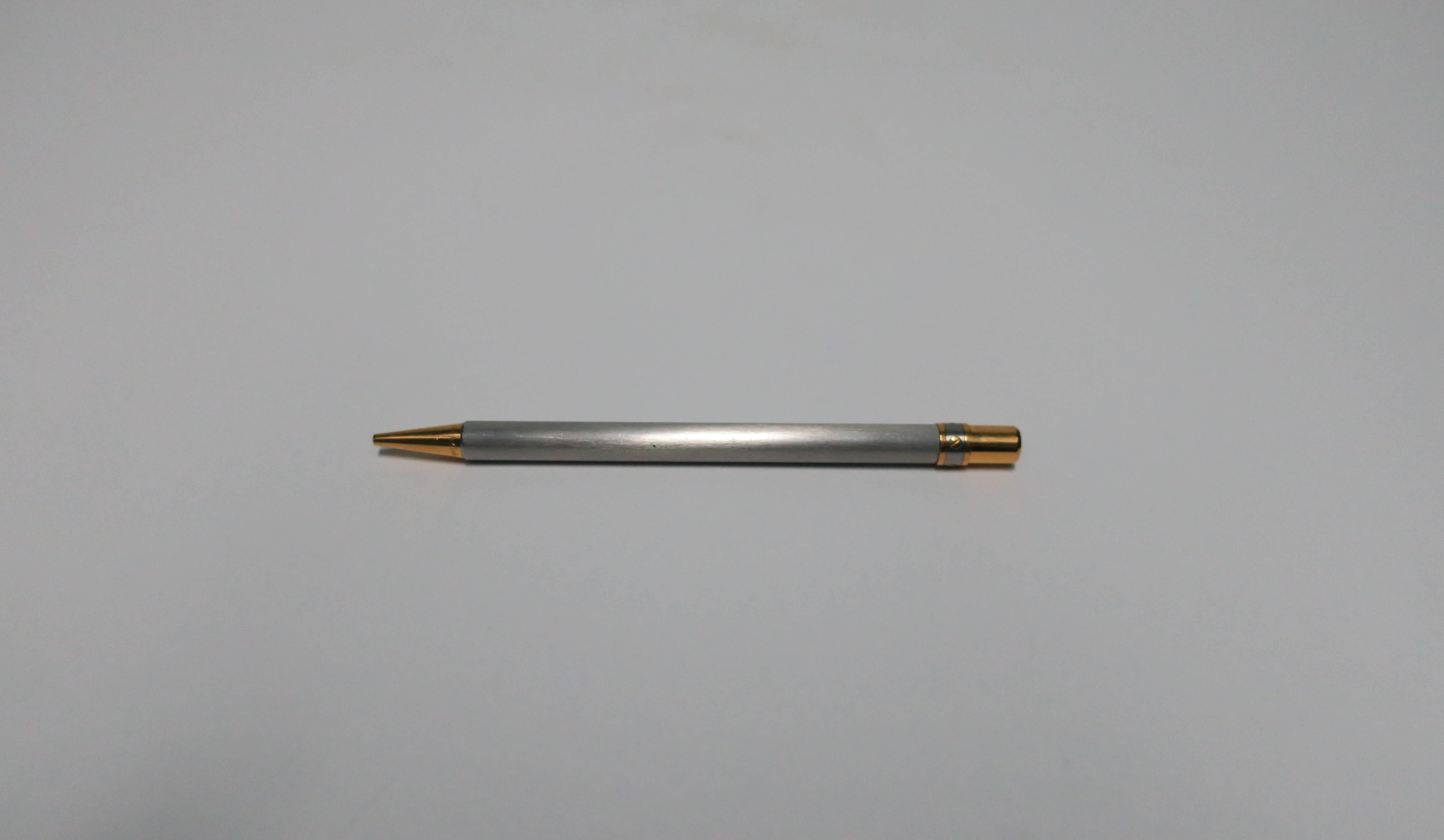A substantial vintage two-tone Santos de Cartier ballpoint pen in a brushed metal steel and a golden-finish. Cartier engraved near ballpoint on gold metal as show in image. Cartier double C logo at opposite end of pen, as shown in image. Made in
