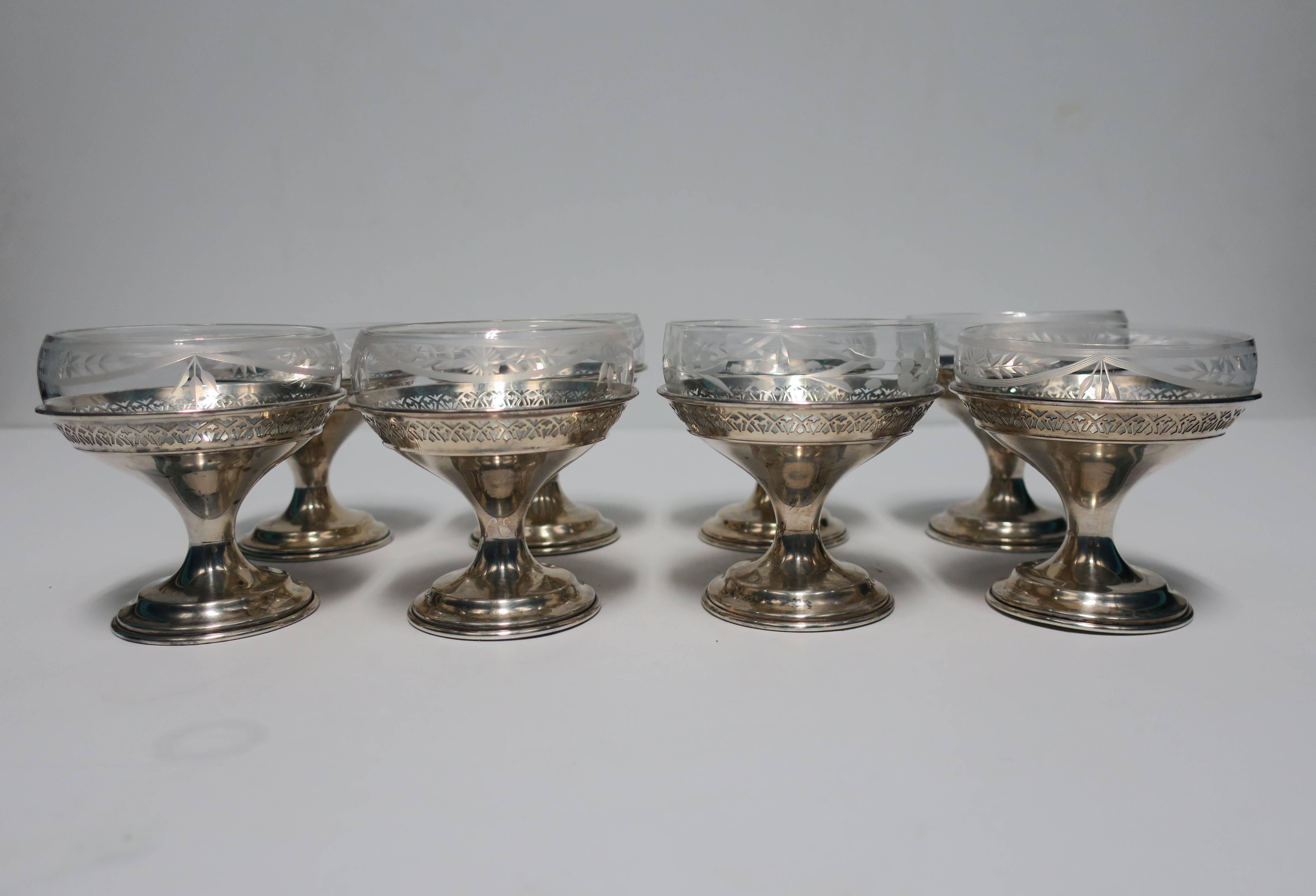 Set of 8 Available Here for $950

A beautiful vintage set of eight (8) sterling silver and cut crystal Champagne coup glasses or dessert vessels by Wallace. With maker's mark (WALLACE) on bottom and marked STERLING. Beautiful perforated details