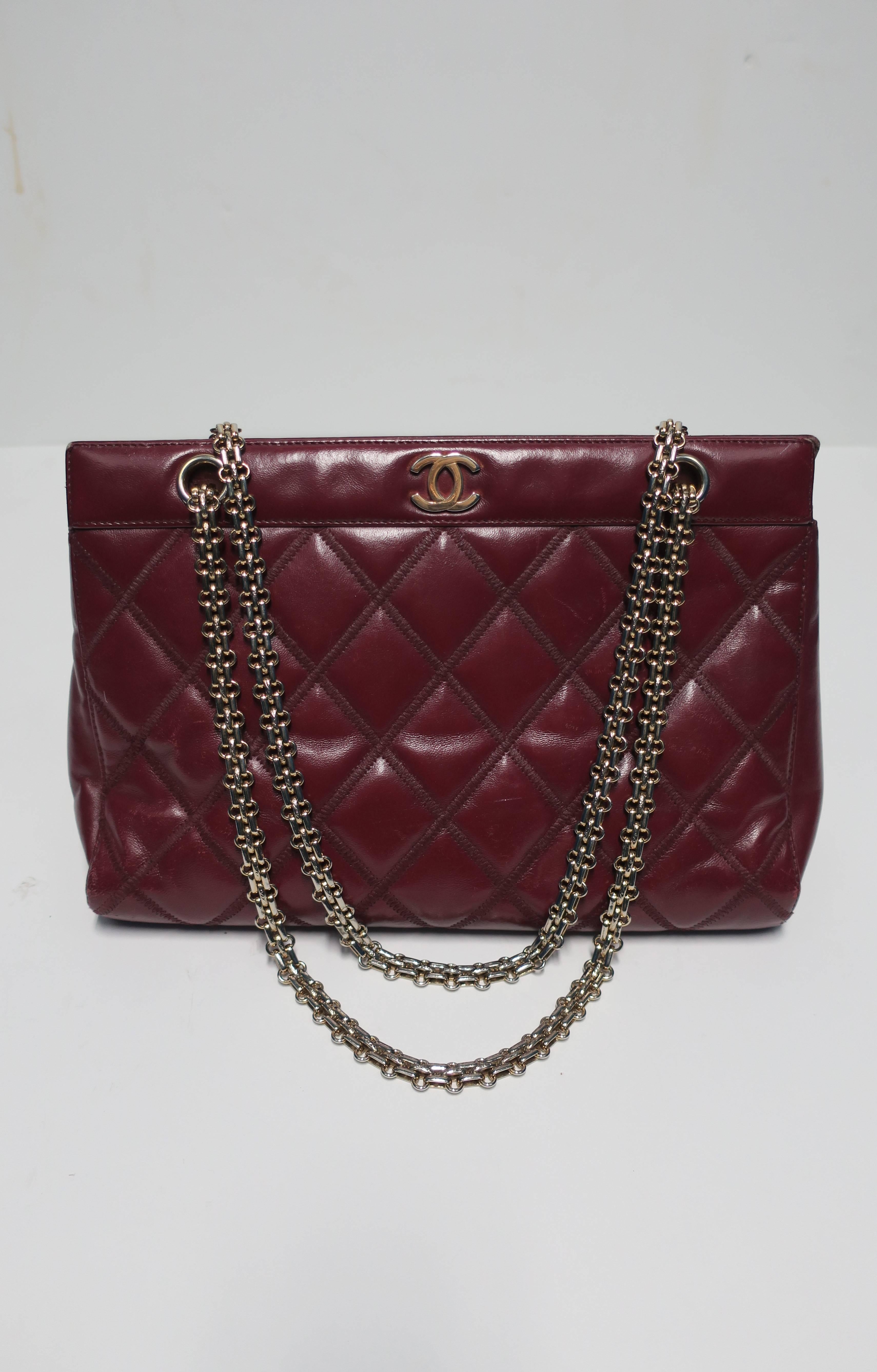 Authentic CHANEL burgundy red quilted leather handbag with gold-tone hardware including gold-tone double CC on front. Circa 1990s. Handbag contains hologram label reading authentication number #6760781. Handbag contains five separate compartments.