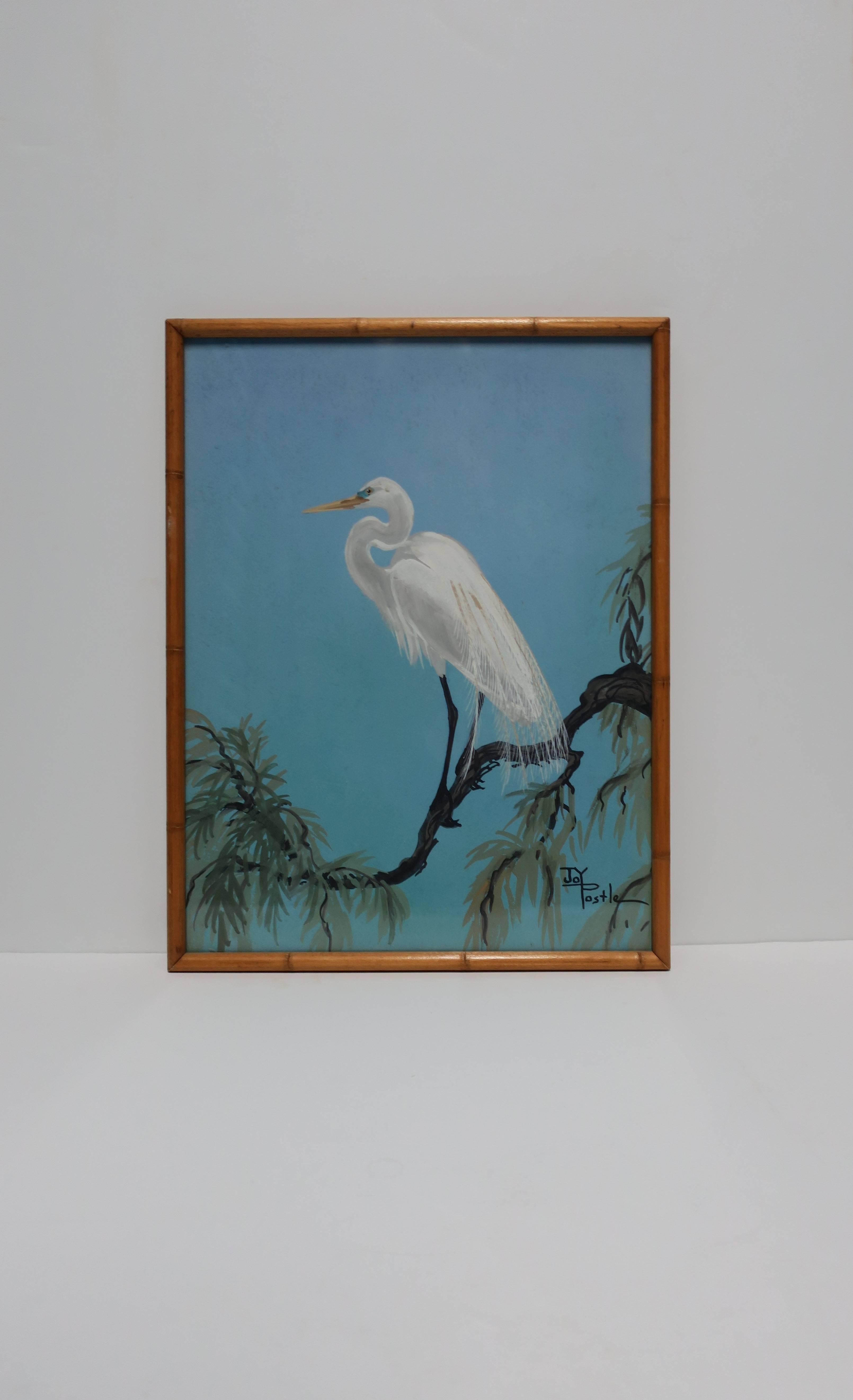 A signed vintage watercolor painting by Artist Joy Postle. Painting, with white Egret bird perched on a tree branch and a turquoise blue sky background, is embraced by a beautiful wood frame in a faux bamboo style. Artist: American, Joy Postle,