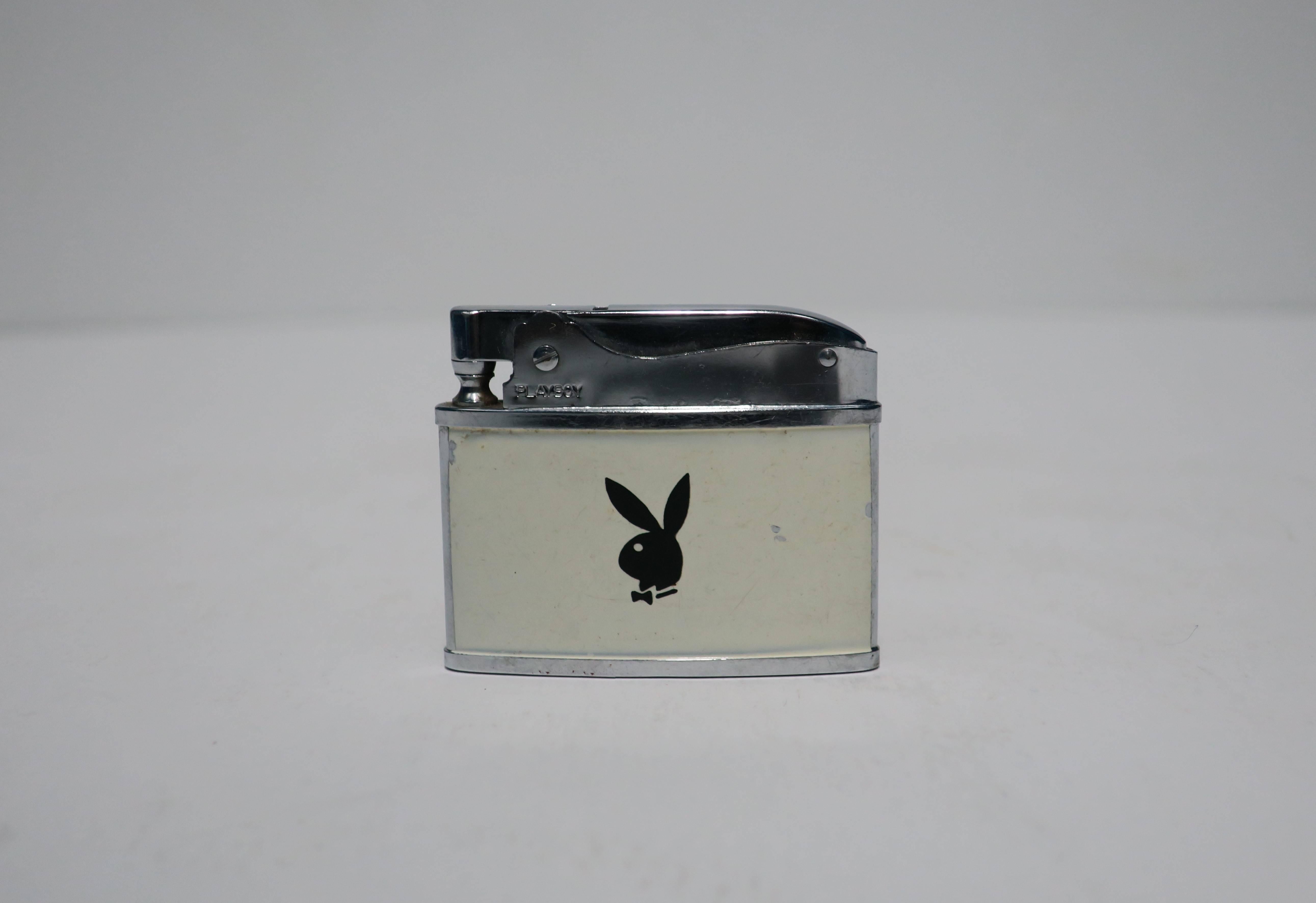 A vintage chrome lighter with black Playboy bunny on white background, circa 1970s. In working order. With maker's mark, "Playboy," on front chrome area and underneath, both shown in images.