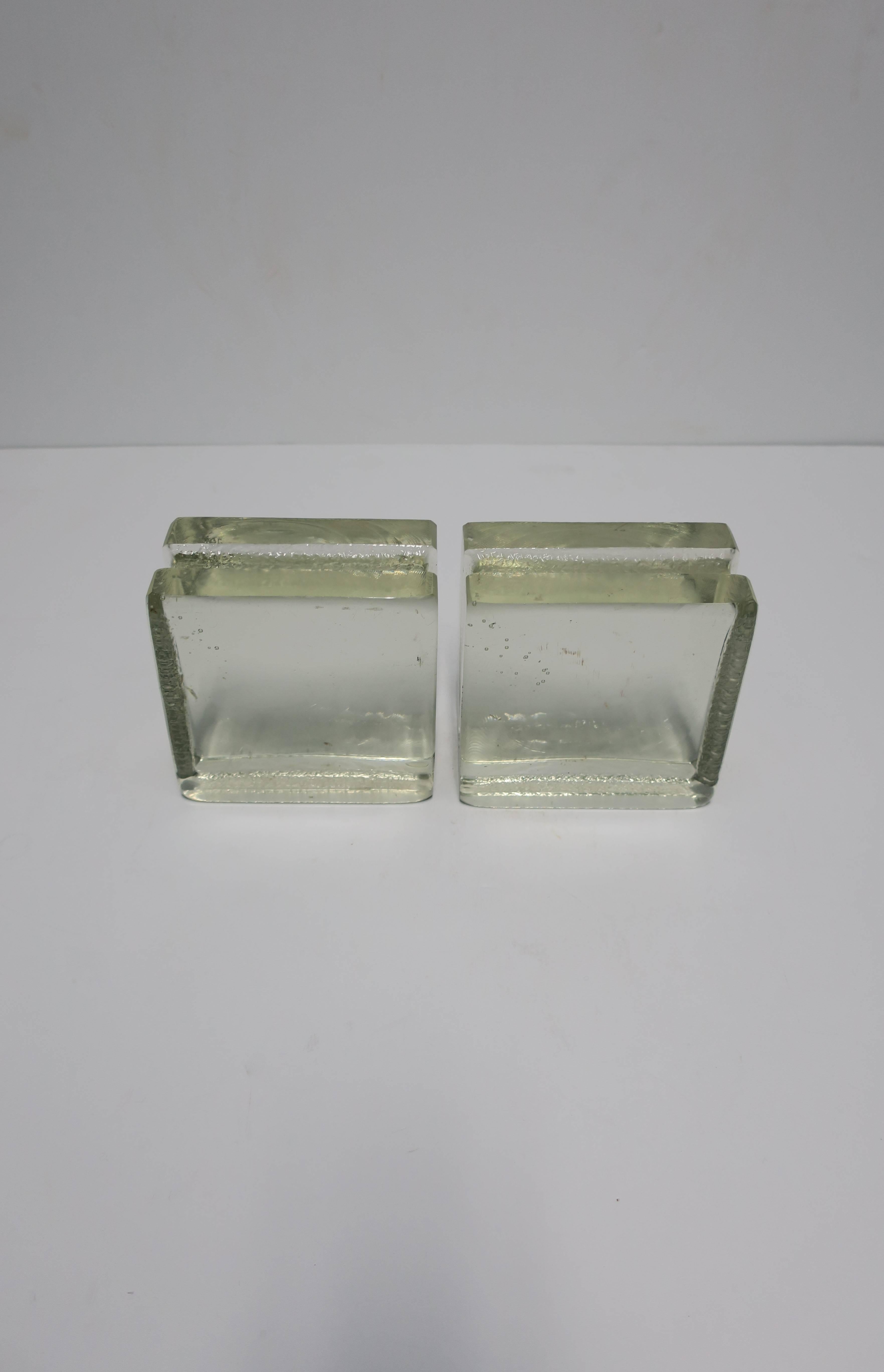 A pair of Postmodern or Modern style solid clear glass-block bookends. 

Each measure 5 in. H x 5 in. W x 2.5 in. D. 


