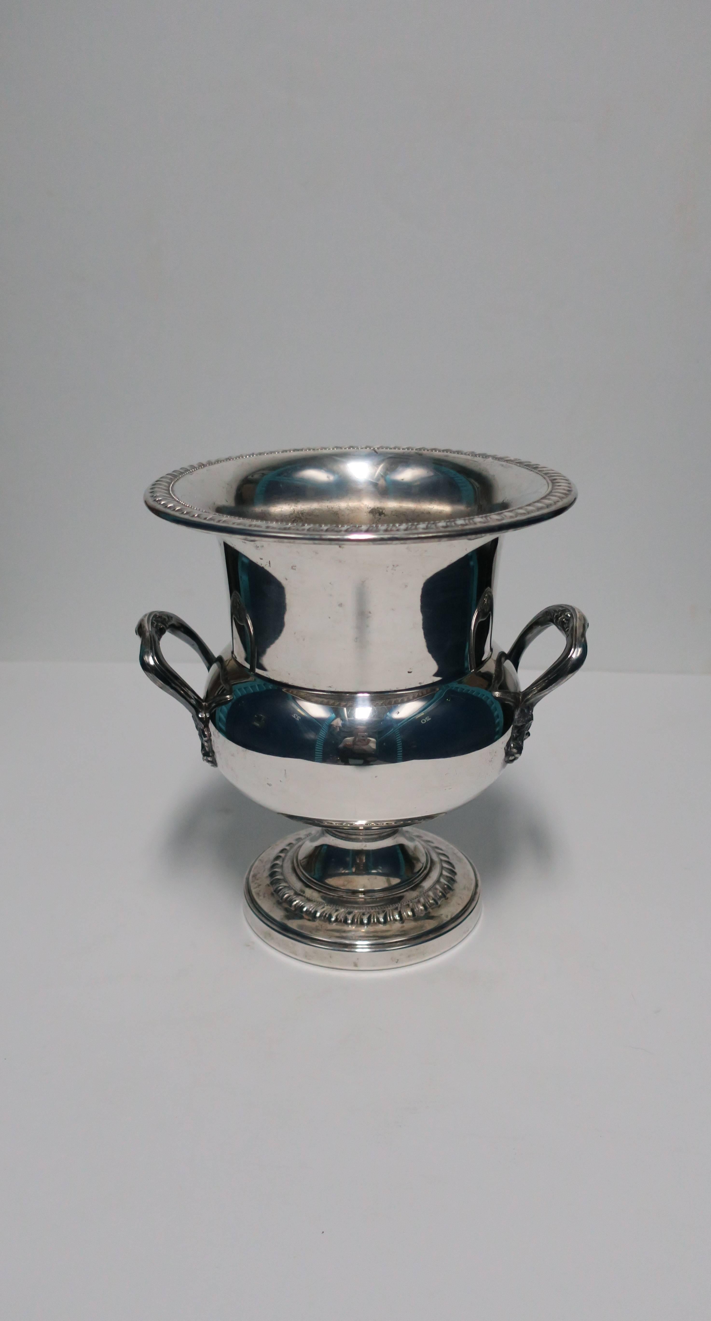A vintage silver over copper urn form champagne or wine cooler by Sheridan. Maker's mark on bottom as show in image #10. Beautiful details around top, handles and base. Item available here online. By request, item can be made available by