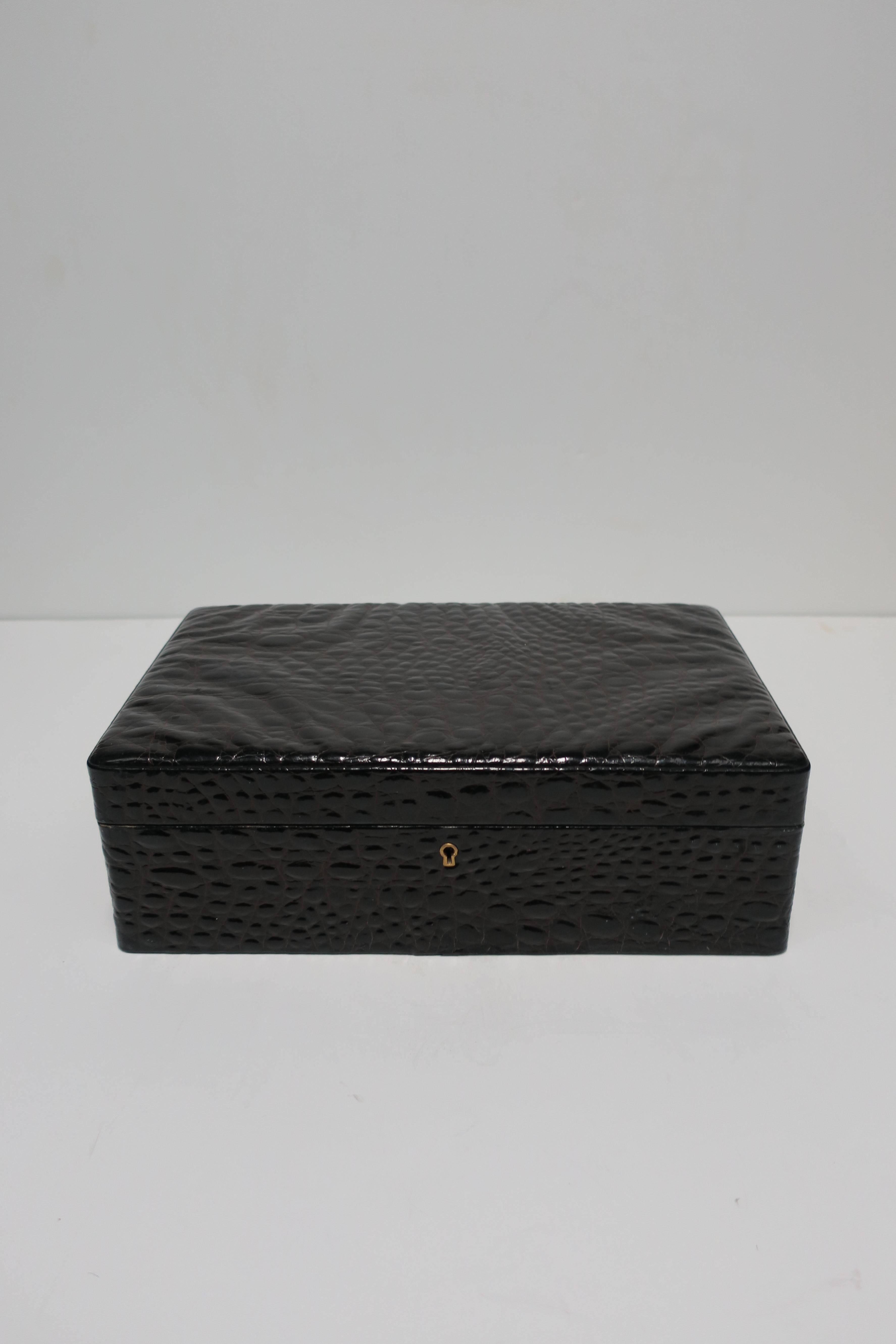 A beautiful large size vintage faux crocodile wrapped jewelry box. Box is dark brown faux patent crocodile on the outside; on the inside it's lined with light brown ultra-suede. Rectangular jewelry box has removable tray. 

Box measures: 13.25 in. W