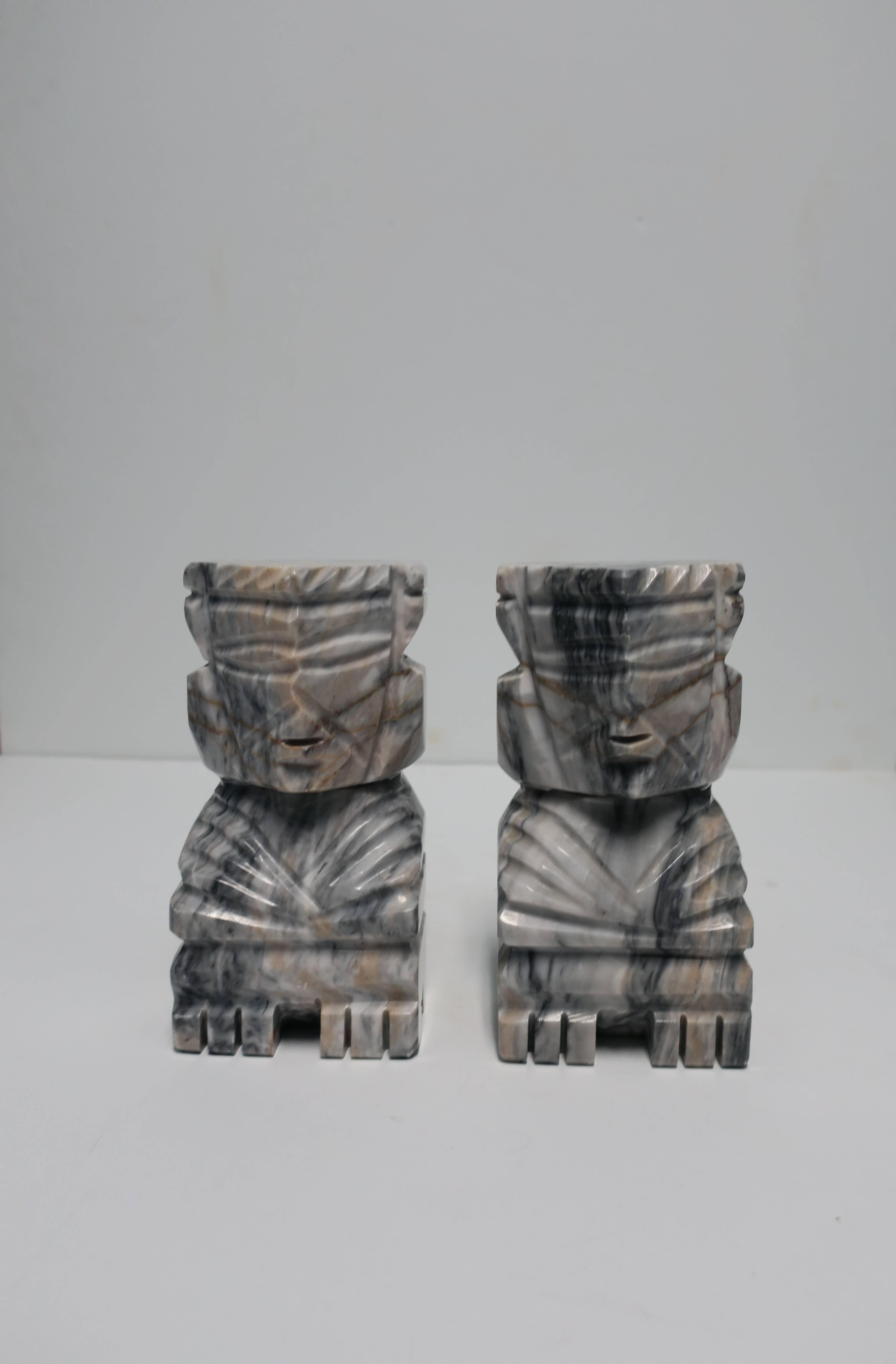 A substantial pair of tall, carved, tribal marble bookends, sculptures, or decorative objects, circa 1970s. Marble is white, black, grey, and tan. Demonstrated as bookends in images #9 and 10. Measuring 8