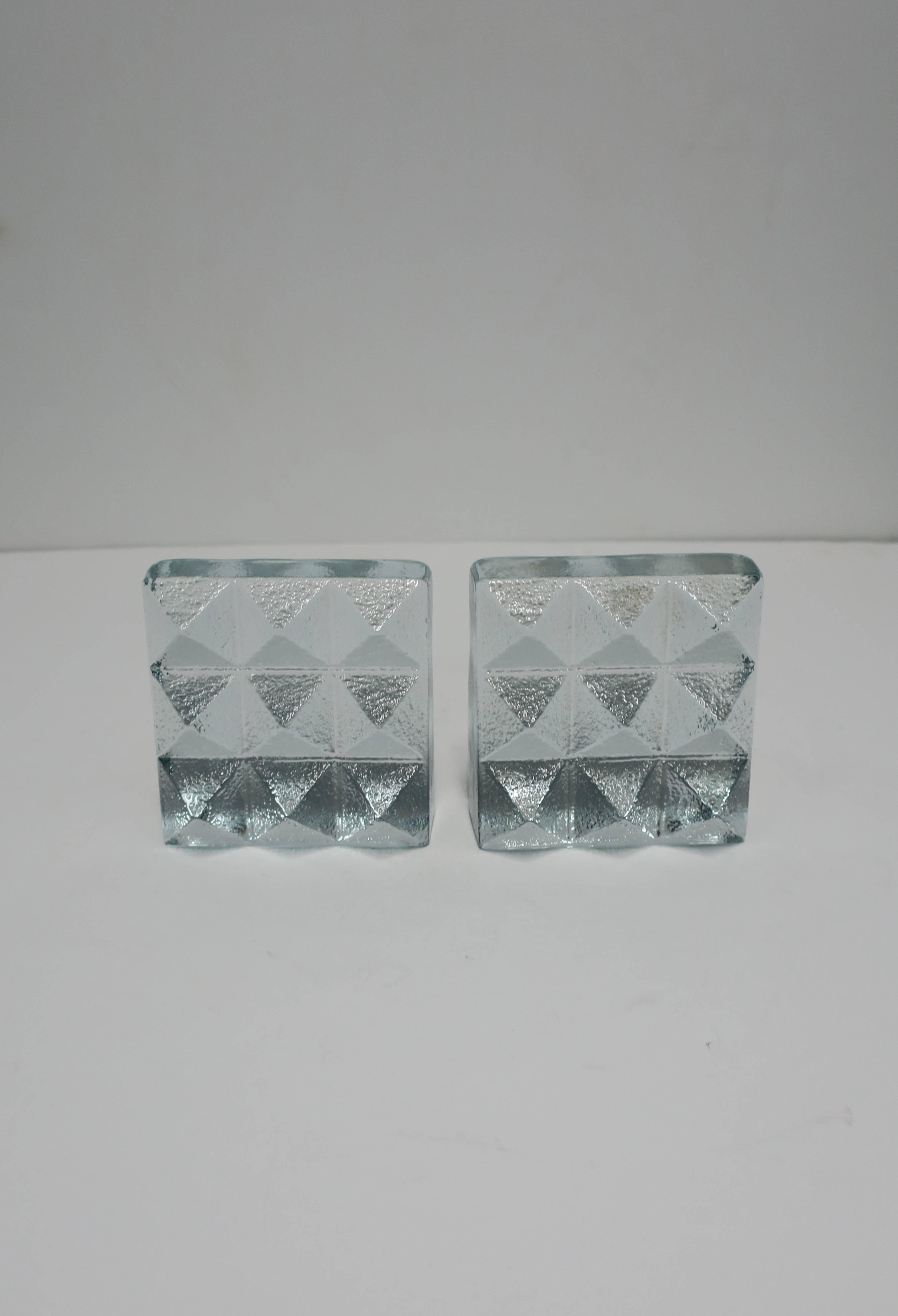 A pair of solid glass textured 'pyramid' stud bookends from Blenko Glass, circa late-20th to early 21st century, USA. Glass is clear with a hint of an ice blue hue. 

