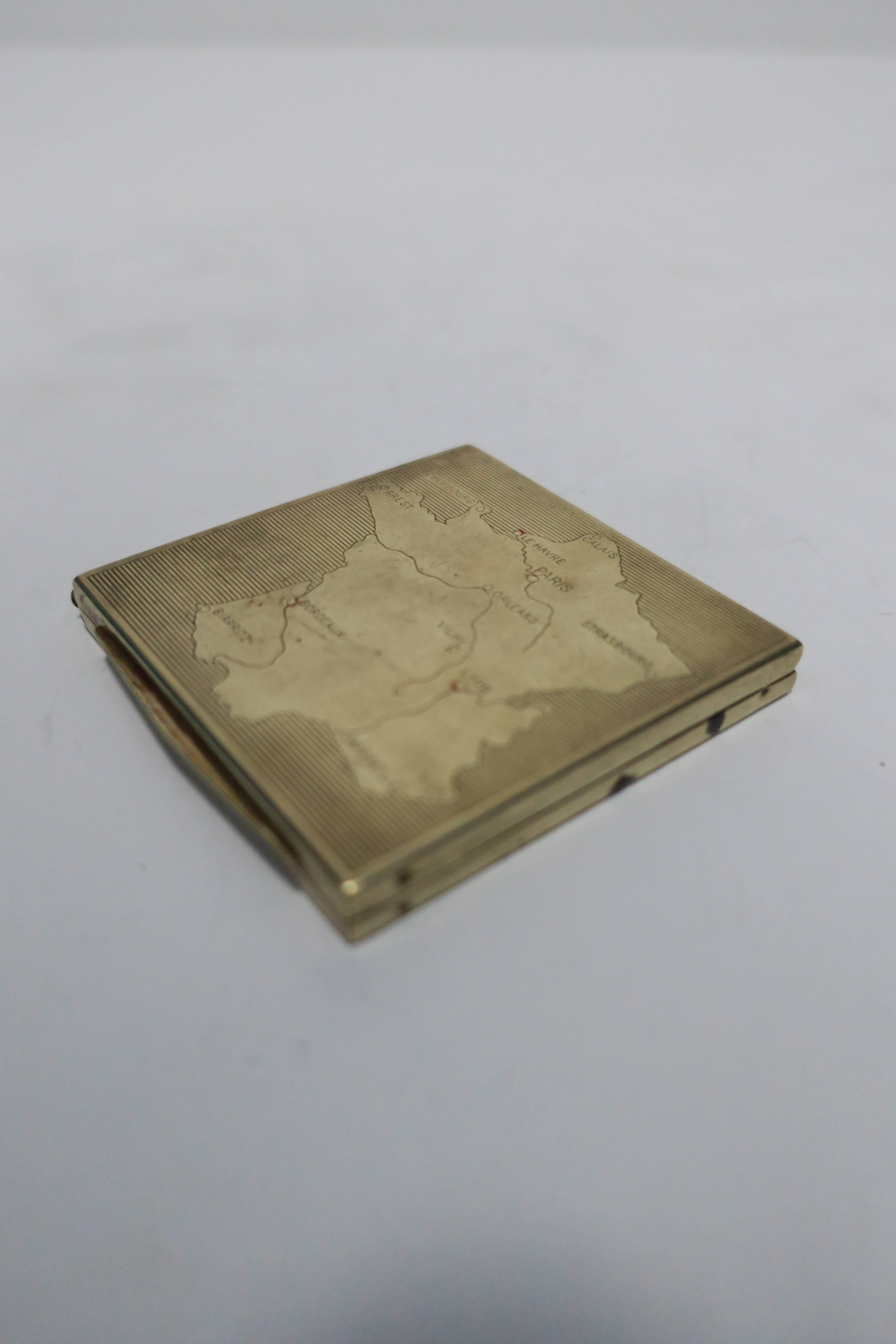 A vintage brass makeup mirror compact case with map of France embossed on front. Case measures: 2 3/8