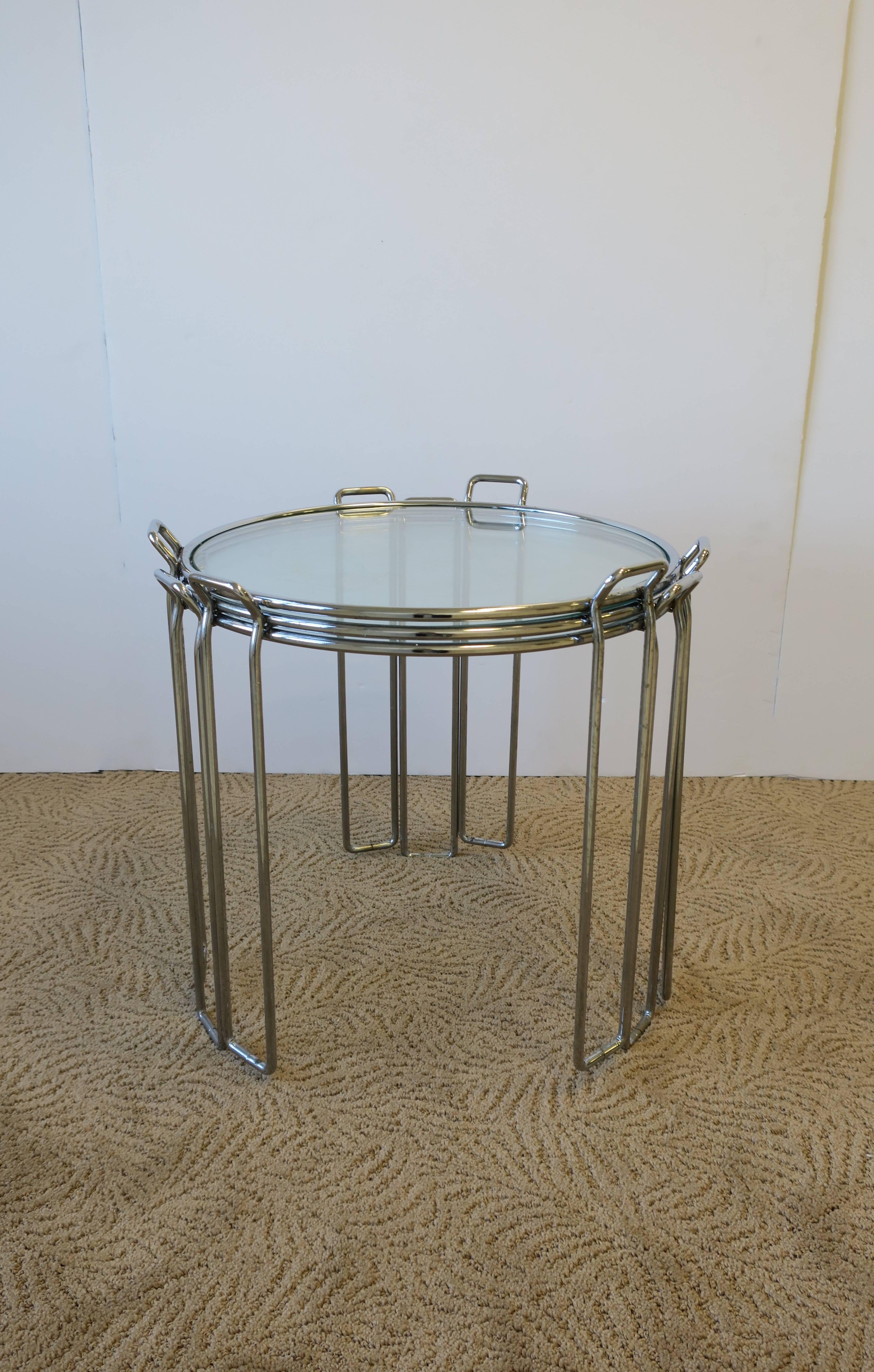 Vintage Modern trio (3) of side, nesting or stacking tables, with tubular chrome frames and circular glass tops. Each table frame is made with three small chrome handles for easy lifting or stacking. Convenient enough to use one side table at a time