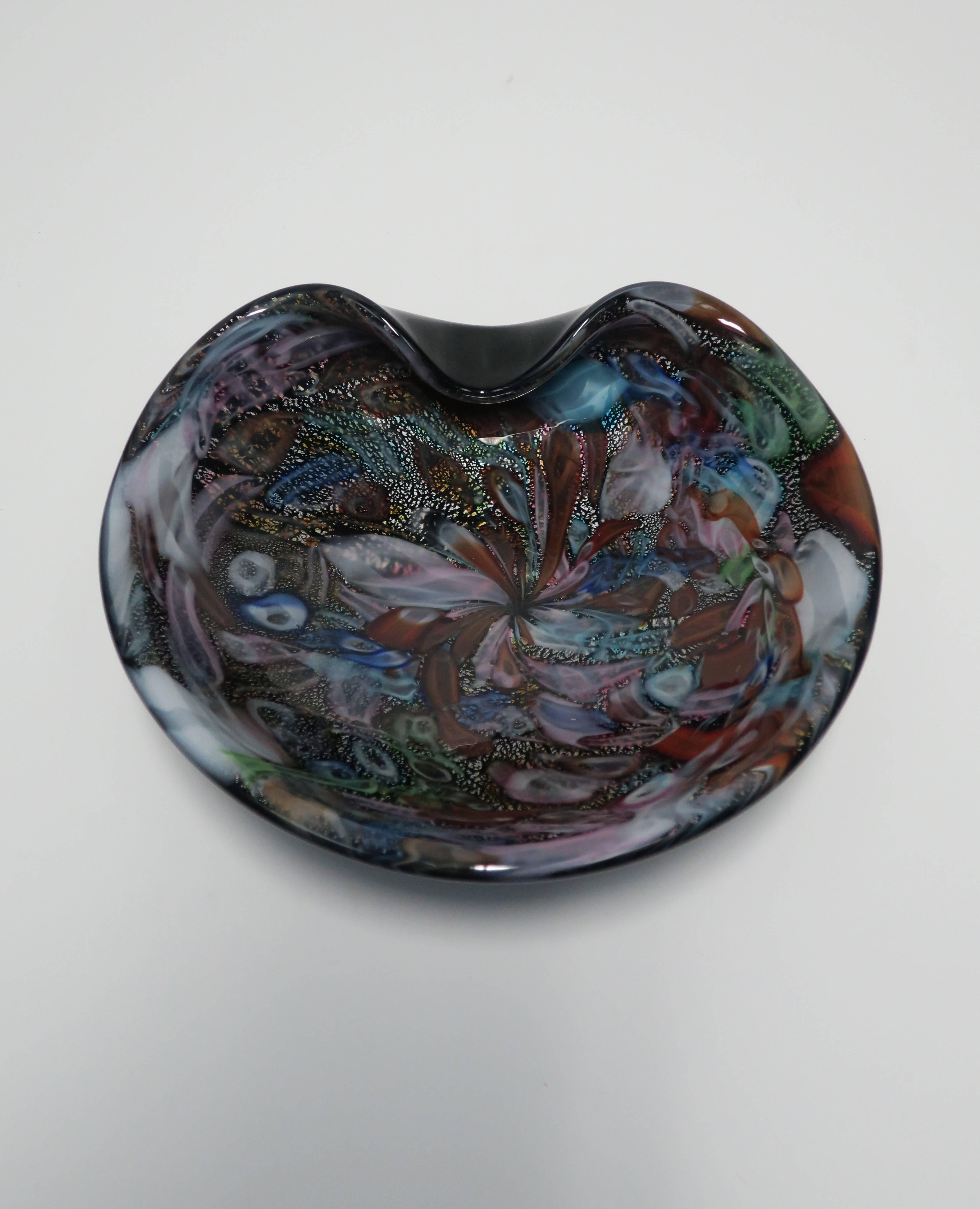 A beautiful large vintage black and multi-colored Italian Murano art glass bowl, Italy, circa 1960s. Bowl has a solid black bottom with and organic bend at top. Swirls of colored Murano glass include white, blue, red, green, pink and shimmering