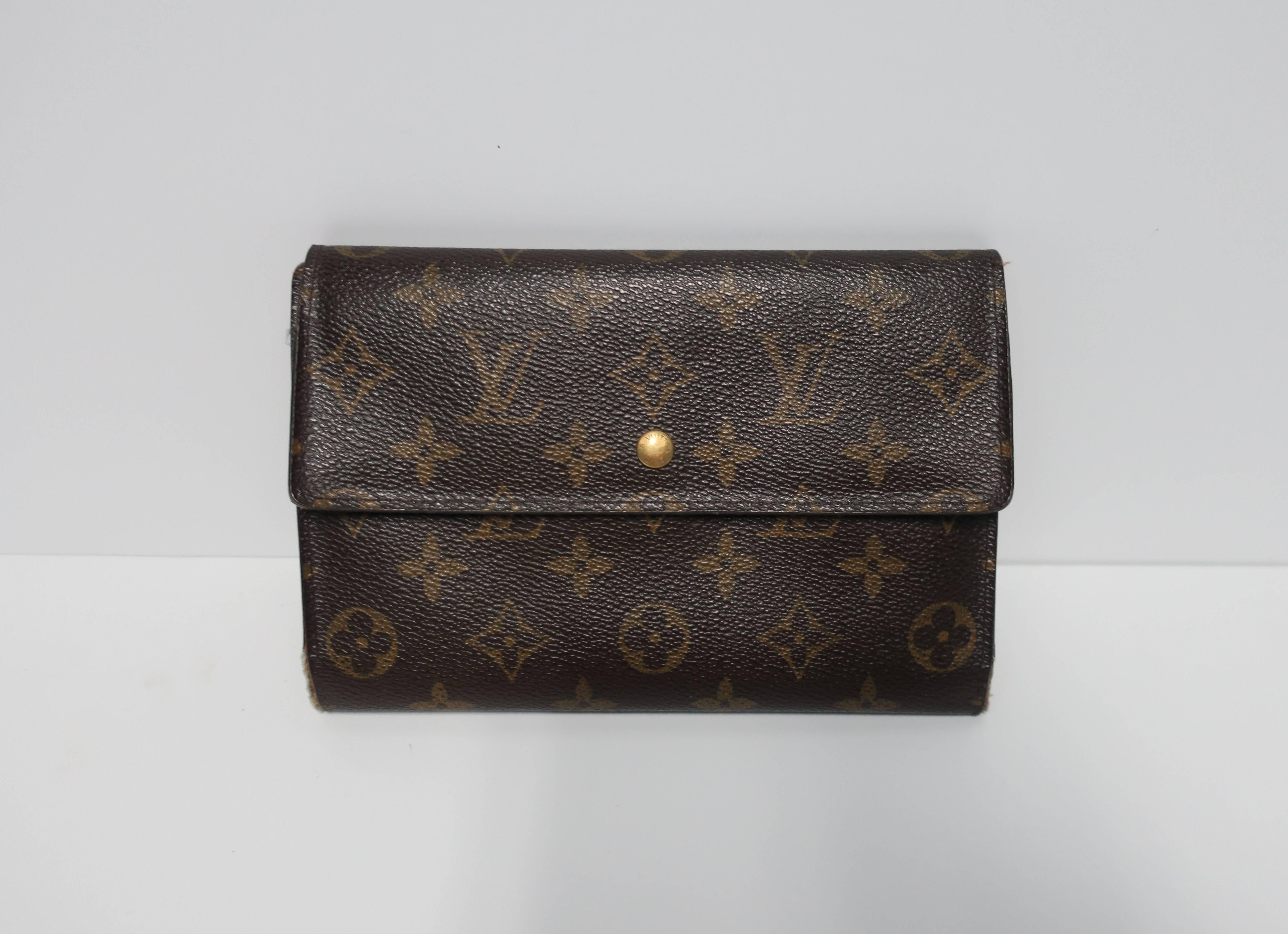 An authentic Louis Vuitton wallet and credit card holder case in the classic, iconic monogrammed canvas pattern and brown cowhide leather, circa 2006. This LV Louis Vuitton wallet features several areas on the inside; wallet for currency, receipts,