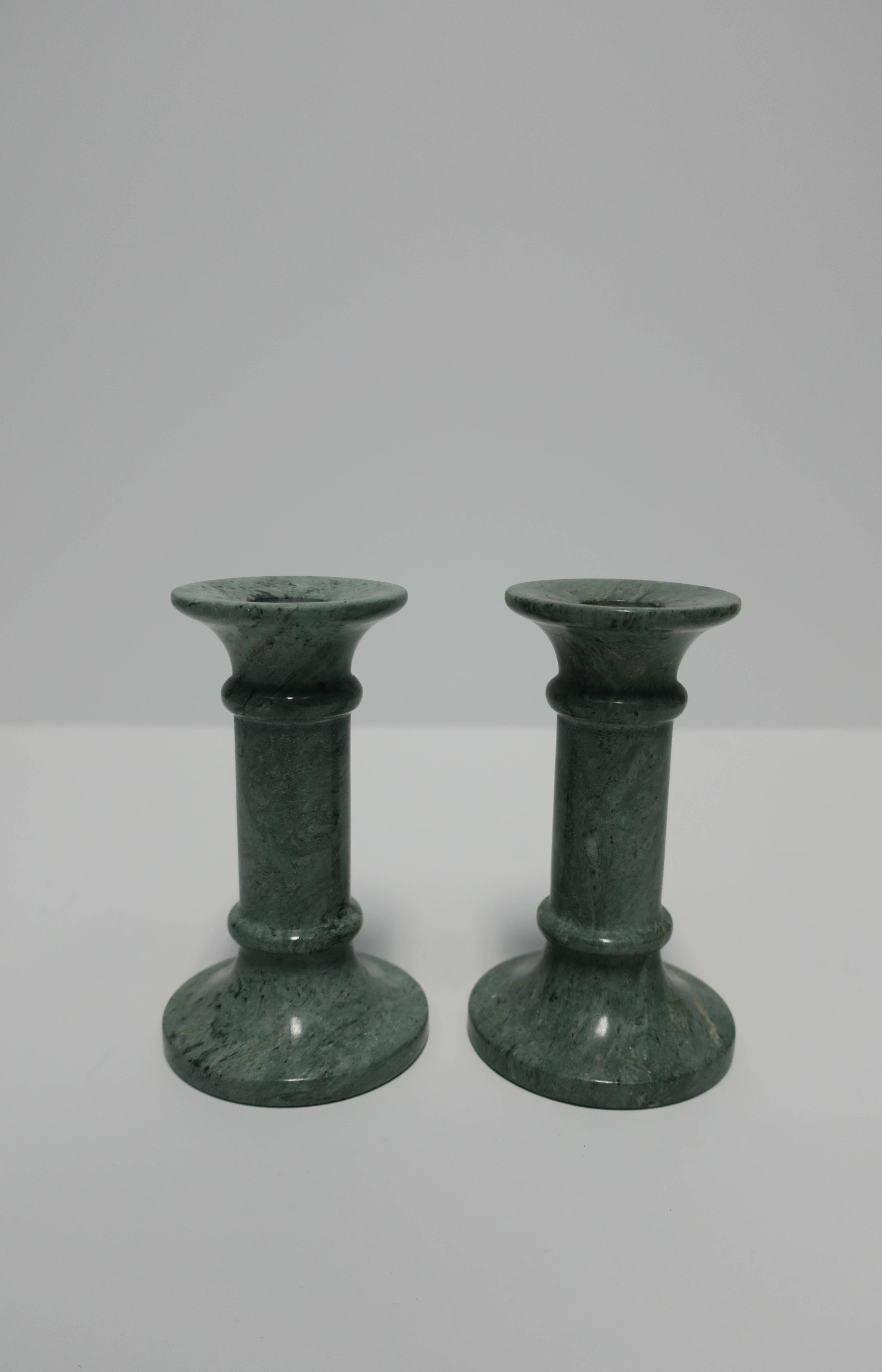 A pair of medium to dark green marble candlestick holders. A single piece of marble, carved and polished smooth, circa 1970s, late-20th century. Measuring 5.25