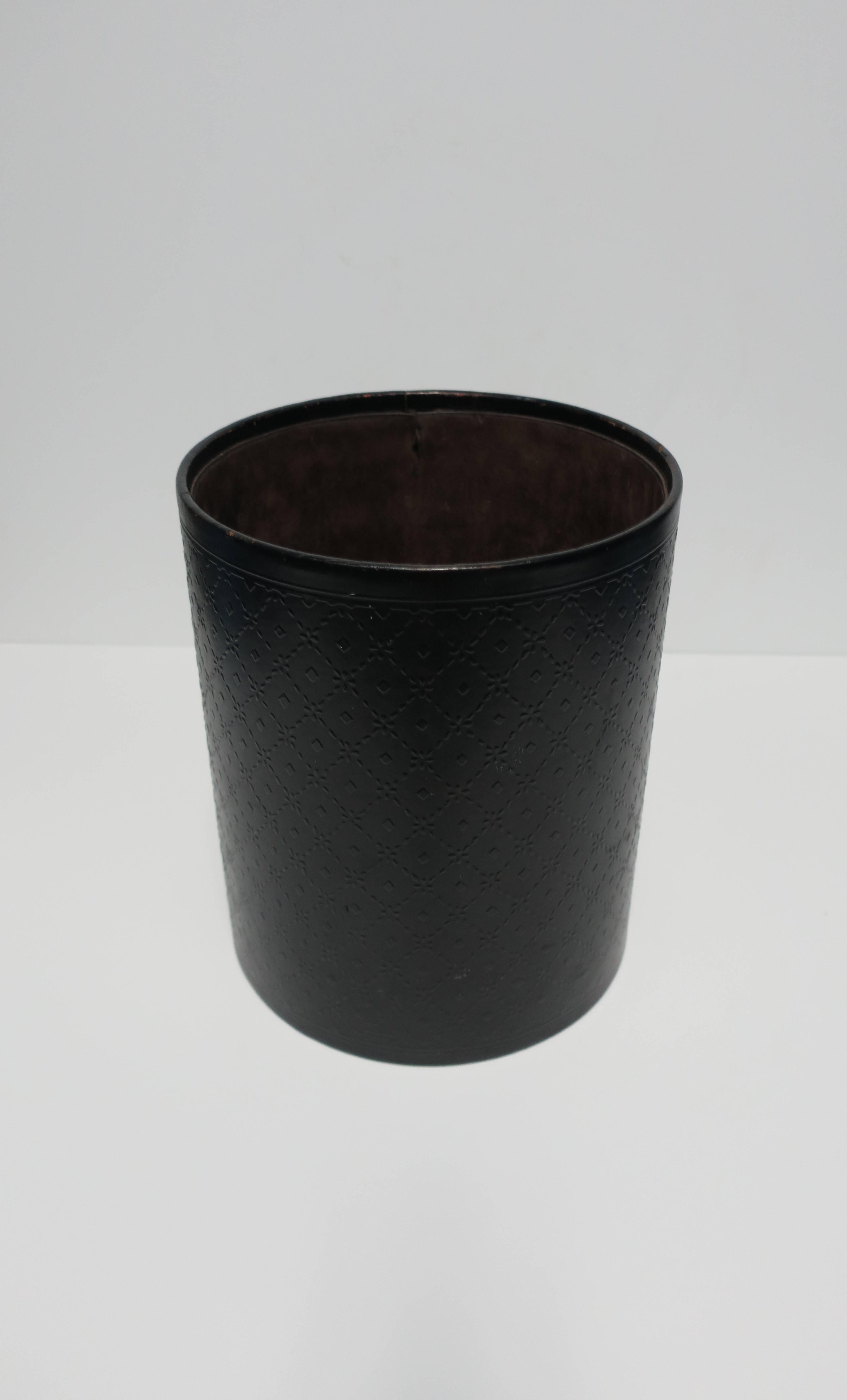A vintage Italian black embossed leather wastebasket or trash can, marked made in Italy on bottom as show in image #10. Exterior has a diamond embossed design. Interior has a dark brown thin velvet lining with a similar look and feel to suede.