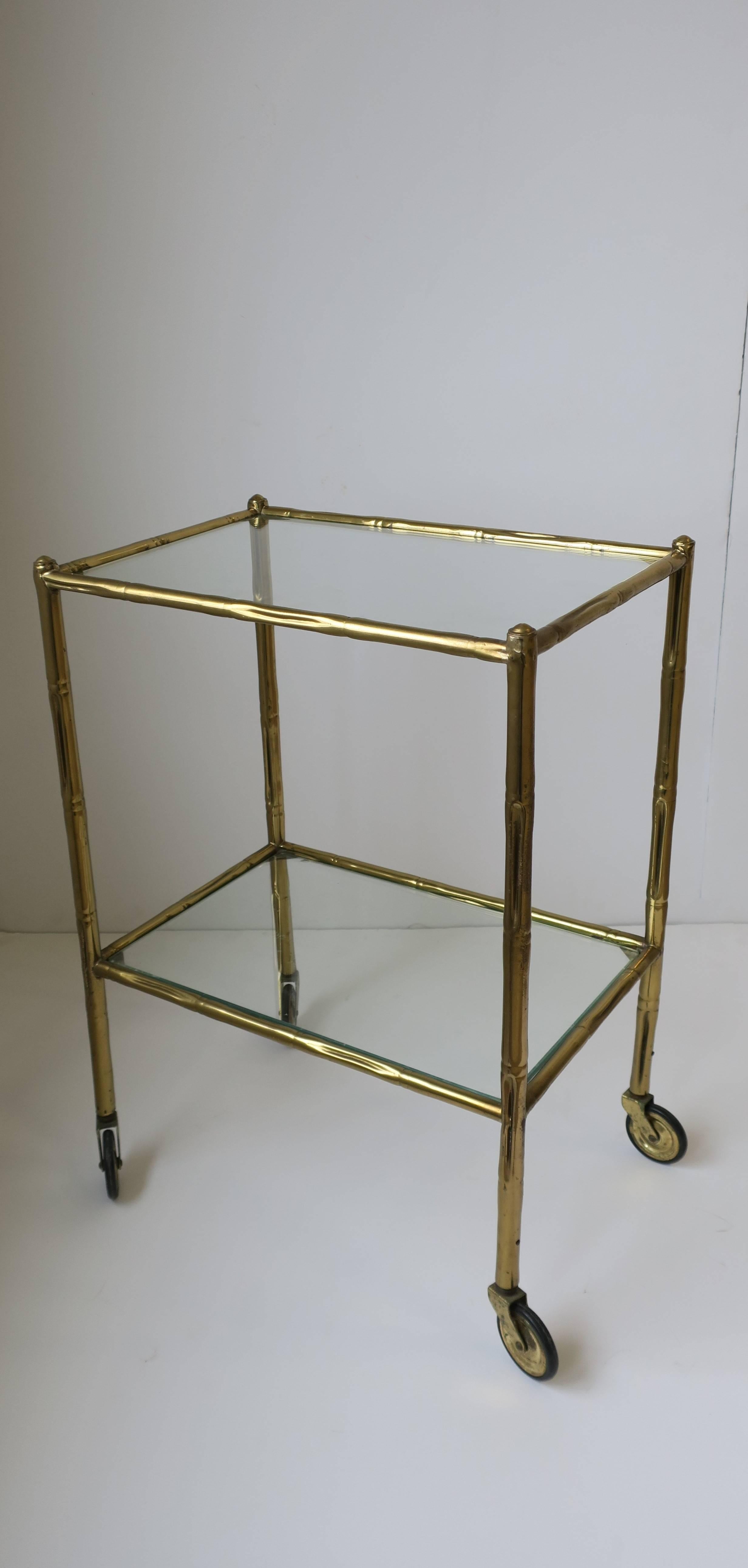 A small vintage Italian bass and glass bi-level bar cart table. Piece can also work as a side table or end table. Frame is a brass 'bamboo' design. Italy, circa early 20th Century. Measurements: 21 in. H x 15 3/8 in. W. x 10.50 in D.

Item available