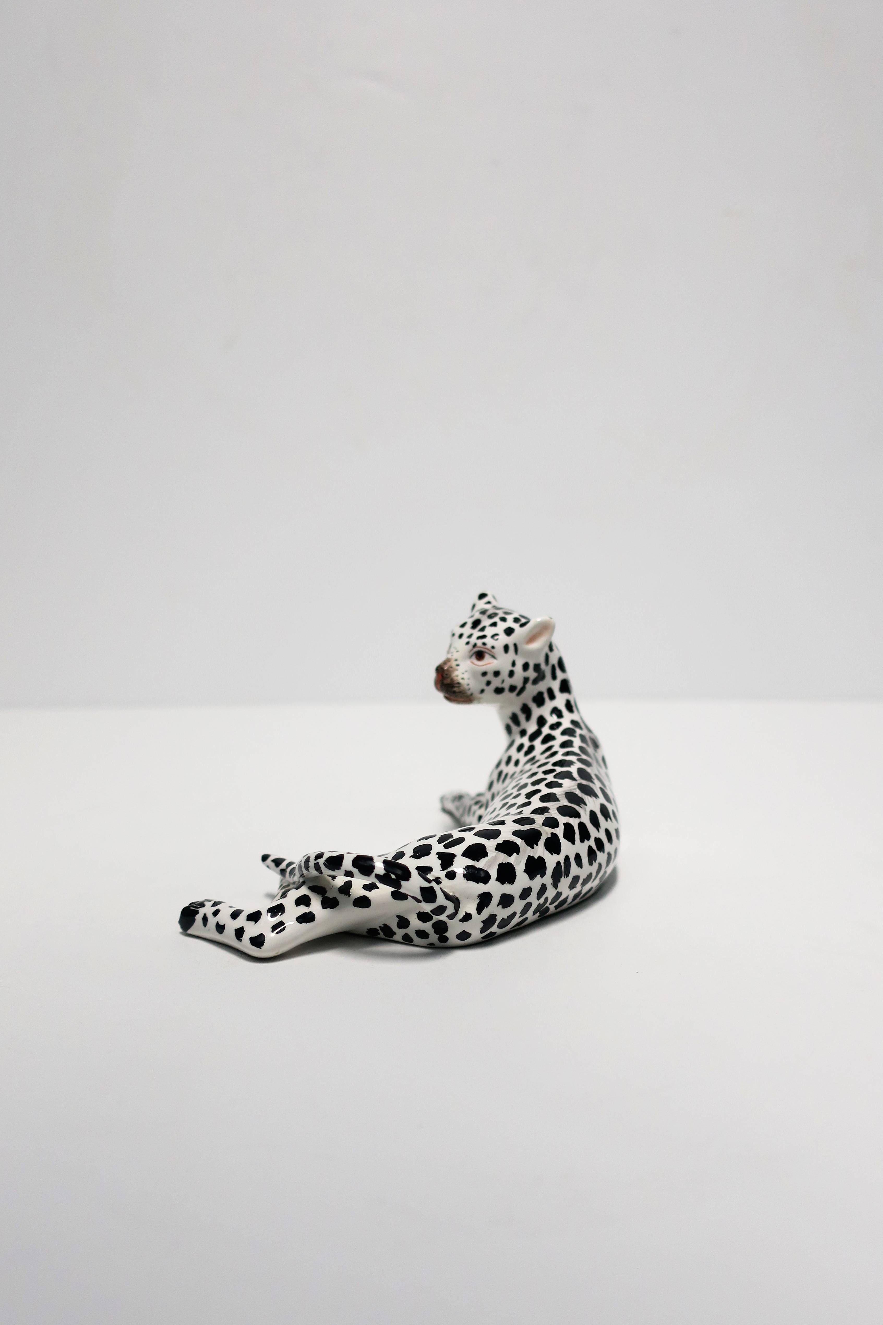 A beautiful and striking vintage Italian Art Deco black and white porcelain cheetah or leopard animal cat sculpture, circa Mid to Late 20th Century, Italy. Marked 'ITALY' on bottom as show in image #10. 

Measures:  3.25 in. H x 3 in. D x 6.5 in. W